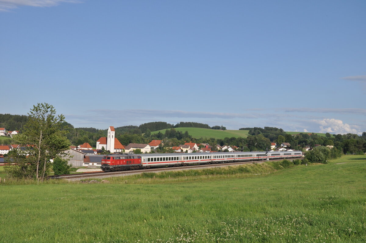 218 495-0 ist am Abend des 09.07.2021 mit dem umgeleiteten IC 2013 auf dem Weg nach Oberstdorf und passiert dabei den Ort Günzach. 