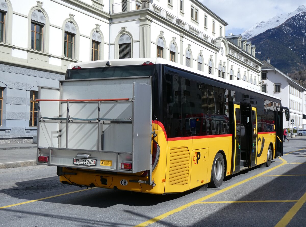 (272'815) - PostAuto Wallis - VS 516'247/PID 11'446 - Iveco am 11. Mrz 2025 beim Bahnhof Brig
