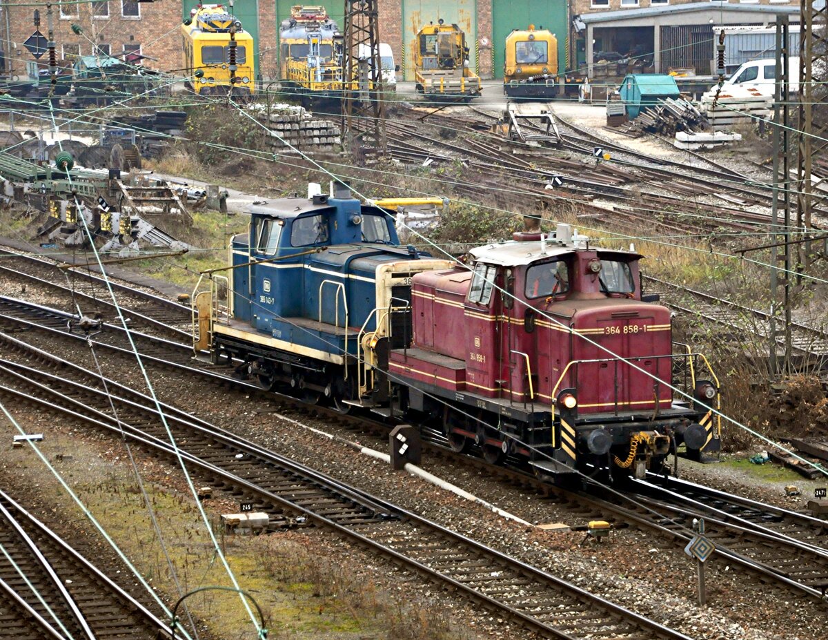 364 858-1 und 365 143-7 in Doppeltraktion in Ulm am 14.12.2013. Die 364 wird manuell bedient, während die 365 im Funk gesteuert wird (am seitlichen Licht am Führerstand zu erkennen).
Im Hintergrund sind diverse Bahndienstfahrzeuge zu erkennen. 