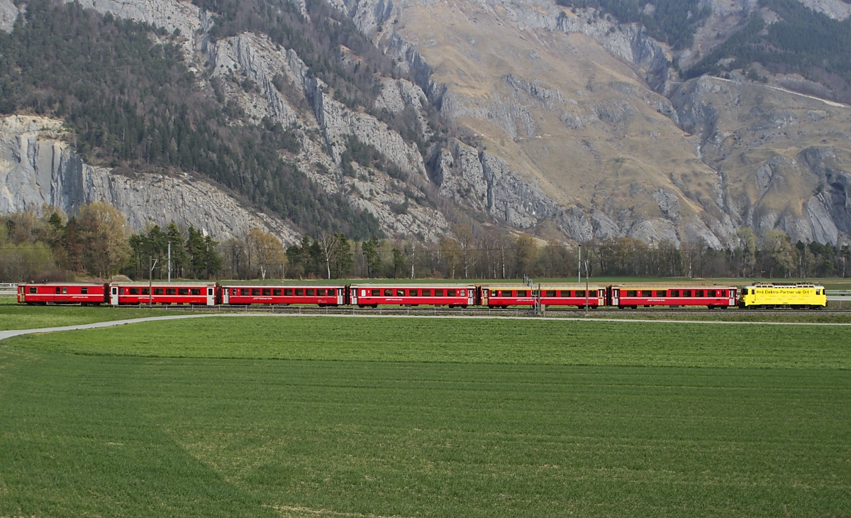 Am 29.03.2022 ist die für Burkhalter Eletro werbende Ge 4/4 II 612  Thusis  bei Felsberg in Richtung Chur unterwegs