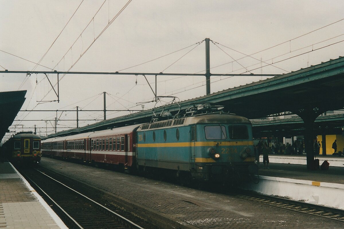 Am grauen 17 September 2004 steht NMBS 2234 mit ein Schnellzug nach Oostende in Gent Sint-Pieters. Die Reihe HLE22, die rote UCI_Reisewagen (ex-SNCF) und die alter Bahnsteige von Gent Sint-Pieters sind alle Vergangenheit.