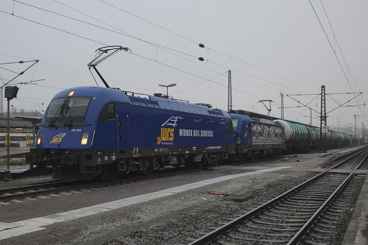 Am nebligen Nachmittag von 29 Dezember 2025 steht WRS 183 004 in Neulackierung mit ein Kesselwagenzug in Offemburg.