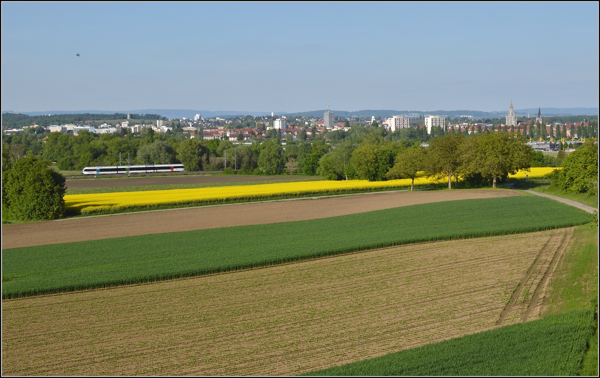 Bahn im Tägermoos. 

S14 Weinfelden-Konstanz mit GTW 2/8 im Anflug auf Kreuzlingen. Im Hintergrund die  Skyline  von Konstanz. Mai 2014.