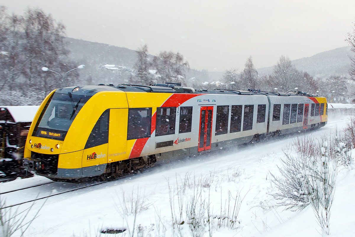 
Bei Schneefall....
Der VT 504 ein Alstom Coradia LINT 41 der neuen Generation (95 80 1648 104-5 D-HEB / 95 80 1648 604-4 D-HEB) der HLB (Hessische Landesbahn GmbH) fährt am 08.01.2017, als RB 96  Hellertalbahn  (Neunkirchen - Herdorf - Betzdorf), Umlauf 61776,  und erreicht bald den Bahnhof Herdorf.

Der LINT 41 wurde im Juli 2015 von ALSTOM LHB (Salzgitter) an die HLB für den Standort Siegen ausgeliefert. Eigentlich müssten diese LINT mit der neuen Kopfform ja LINT 42 heißen, da sie mit einer Länge von 42,17 m etwas länger sind als die ursprünglichen LINT 41 (41,81 m). Denn die Bezeichnung LINT 41 bedeutet „leichter innovativer Nahverkehrstriebwagen“, die 41 steht für die Länge der vollen Meter (bei dem ursprünglichen 41,81 m). Wird die Bezeichnung „H“ (LINT 41/H) verwendet, so sind es Hochflur-Fahrzeuge. Dies hier sind aber zweiteilige Niederflur-Dieseltriebwagen, welches man gut an der bis unten gehenden Tür erkennen kann.  

Die LINT-Triebwagen sind in Stahlbauweise ausgeführt. Bei den LINT 41 wird pro Wagenkasten ein Enddrehgestell von einer dieselmechanischen Antriebsanlage mit liegend eingebauten MTU-Reihen-Sechszylinder-Dieselmotoren mit  Leistung von 390 kW über eine Gelenkwelle angetrieben.

Bis zu drei Einheiten sind über automatische Scharfenbergkupplung Typ 10 zu einem Zug kuppelbar.

Als Bremsen werden druckluftbetätigte Scheibenbremsen verwendet, an je einem Triebdrehgestell befinden sich zusätzlich Magnetschienenbremsen. Als Feststellbremse sind Federspeicher vorhanden. Die Bremsanlagen ist von Knorr-Bremse. Die Fahrzeuge der HLB (wie auch die DB Regio) verwenden zudem Retarder als hydrodynamische Ergänzungsbremse. Die Fahrzeuge verfügen zusätzlich über Rußpartikelfilter.

Die Fahrzeuge verfügen über voneinander unabhängige Führerraumklimaanlagen und Fahrgastraumklimaanlagen. Je Wagenkasten sind zwei Dachklimageräte vorhanden. Die Abwärme der Dieselmotoren wird zur Beheizung von Fahrgasträumen und Führerräumen genutzt. Reicht die Abwärme nicht aus, so werden dieselbefeuerte Zusatzheizgeräte zugeschaltet. Geliefert wird die Heizungs-, Lüftungs-, Klimaanlage von „Spheros“ (ehemals Webasto).

Die Steuerschränke im Führerraum werden als Sonderlösung von Rittal produziert und von Alstom ausgerüstet.

Technische Daten:
Baureihenbezeichnung: 1 648 (anstelle der alten Ausführung 0 648)
Hersteller:	Alstom Transport Deutschland GmbH
Spurweite: 1.435 mm (Normalspur)
Radsatzfolge: Bx’ (2) By’
Länge: 42,17 m
Breite: 2.750 mm
Drehzapfenabstand: 16.500 mm
Drehgestellachsstand (Antriebsgestelle): 1.900 mm
Drehgestellachsstand (Jakobsgestell): 2.700 mm
Eigengewicht: 76,3 t
Geschwindigkeit: 140 km/h
Leistung: 2 x 390 kW
Fahrgastsitzplätze: 8 in der 1. Klasse und 94 in der 2. Klasse
Niederfluranteil: 60 %
Kupplungstyp: Scharfenbergkupplung Typ 10
Fahrzeugbestand der HLB: 7
