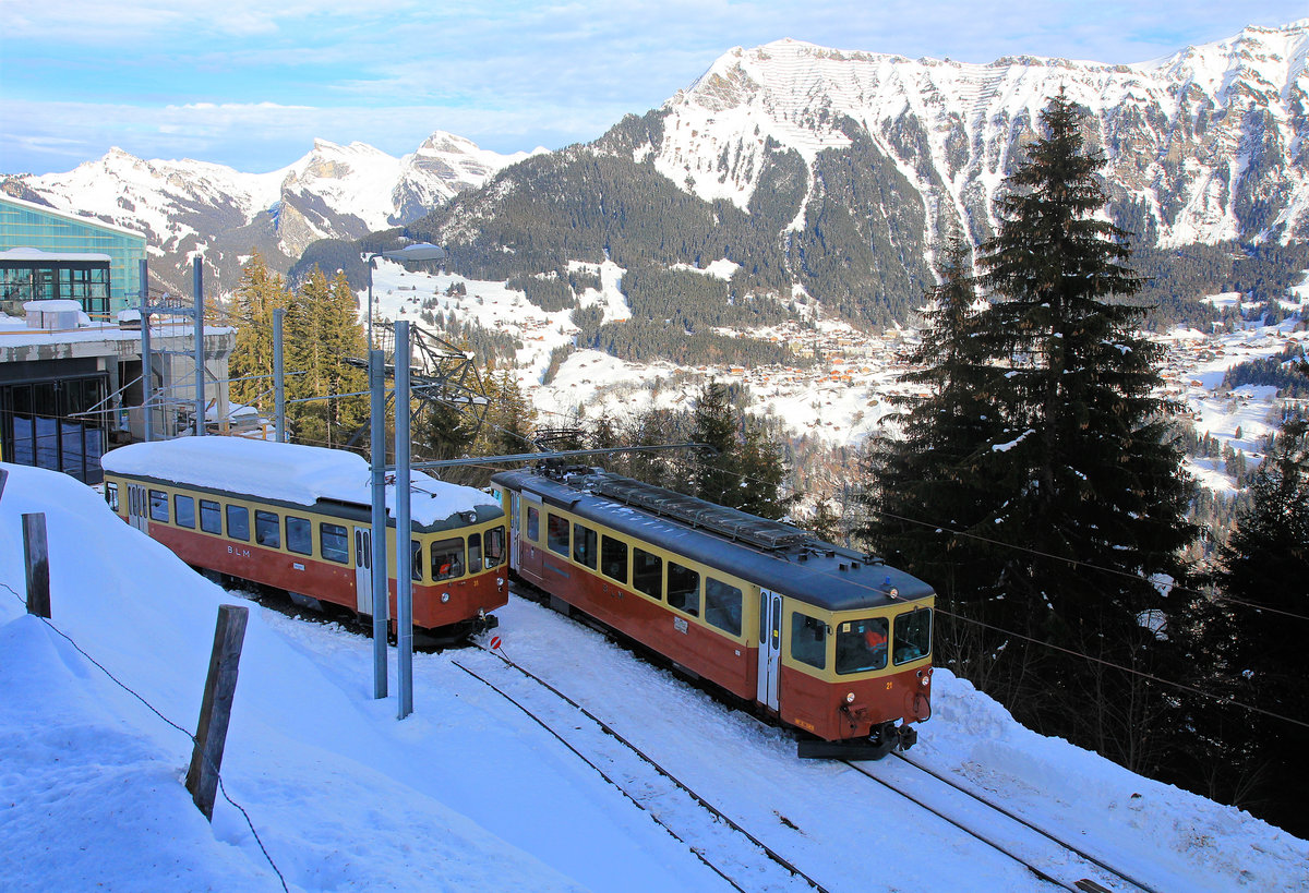 Bergbahn Lauterbrunnen - Mürren: Triebwagen 21 verlässt Grütschalp, während Wagen 31 (ex-ASm 102 ex-OJB 82) daneben abgestellt ist. 14.Dezember 2020 