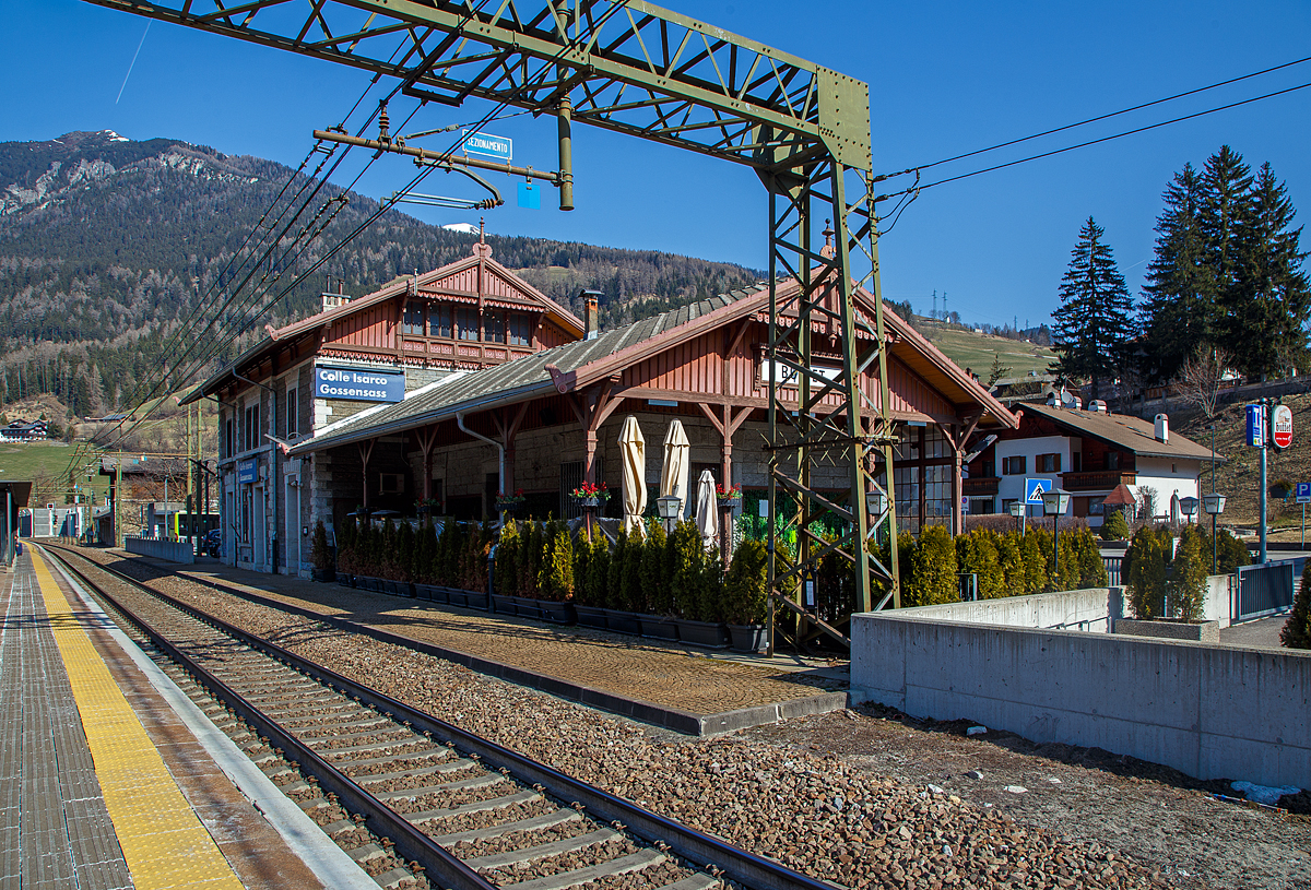 Blick auf den Bahnhof Gossensaß/Colle Isarco am 27.03.2022.
Der Bahnhof Gossensaß (auch Gossensass; italienisch Stazione di Colle Isarco) befindet sich an der Brennerbahn in Südtirol (italienisch Alto Adige), amtlich Autonome Provinz Bozen – Südtirol.

Der Bahnhof Gossensaß ist der erste Haltepunkt im Wipptal südlich des Brennerpasses, zu dem die Bahnstrecke von hier aus über den Pflerschtunnel ansteigt. Er liegt auf 1.066,9 m Höhe nahe dem Zentrum von Gossensaß, dem Hauptort der Gemeinde Brenner, und der durch das Dorf führenden SS 12 (der alten Brennerpass-Straße). 

Der Bahnhof wurde 1867 zusammen mit dem gesamten Abschnitt der Brennerbahn zwischen Innsbruck und Bozen in Betrieb genommen. Durch ihn erlebte Gossensaß bis zum Ersten Weltkrieg seine Blütezeit als bekannter Touristenort. Er konkurrierte mit Orten wie St. Moritz oder Chamonix. 

Das Aufnahmegebäude war zunächst noch relativ kompakt gehalten, wurde wegen der vielen Touristen jedoch noch im 19. Jahrhundert durch einen südlichen Anbau erweitert. Das ursprüngliche Gebäude weist eine Verkleidung aus Grauwacke auf, während dekorative Details wie die Fensterfassungen in weißem Kalkstein gehalten sind. Straßenseitig ist es durch einen in sorgfältigen Details gearbeiteten Dachgiebel aus Holz gestaltet. Der Anbau ist in Brixner Granit gemauert und sticht durch eine hölzerne Veranda hervor. In dem sich heute das Buffet befindet und man auch den Espresso genießen kann. Das Gebäude steht seit dem Jahr 2000 unter Denkmalschutz.

Der Bahnhof Gossensaß wird durch Regionalzüge der Trenitalia sowie der SAD bedient, die auch Busverbindungen zum Bahnhof betreibt. Die Regionalzüge fahren in beide Richtung (Brenner bzw. Bozen) im Stundentakt und werden zu Hauptverkehrszeiten durch Regionalexpresszüge verdichtet.

Uns hat es in Gossensaß sehr gut gefallen, es war einfach zu kurz, so dass wir gerne wiedermal dort hinfahren wollen. Für die drei Tage haben wir uns ein Südtirol/Alto Adige Ticket (eine Mobilcard für 3 Tage) am Automat für 23,00 Euro geholt. So konnten wir mit diesem Ticket Südtirol mit der Bahn erkunden. 

