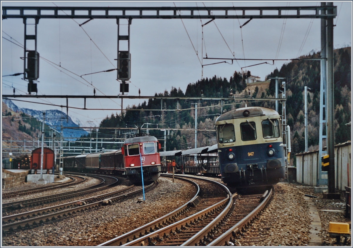 BLS Autoverlad Göschenen - Airolo. Lange Jahre, bis zu Eröffnung des Gotthard Strassentunnels 1981 betrieben die SBB einen Autoverlad durch den Gotthardtunnel. Als dann im Herbst 2001 nach einem Unfall den Strassentunnel für gut zwei Monate gesperrt werden musste, zog die BLS einen Autoverlad auf. 
Während der BLS Autozug in Airolo mit dem Steuerwagen 947 auf die Abfahrt Richtung Göschenen wartet, fährt eine  Re 10/10  durch.. 
Analogbilder vom 16. bzw. 21. November 2001 