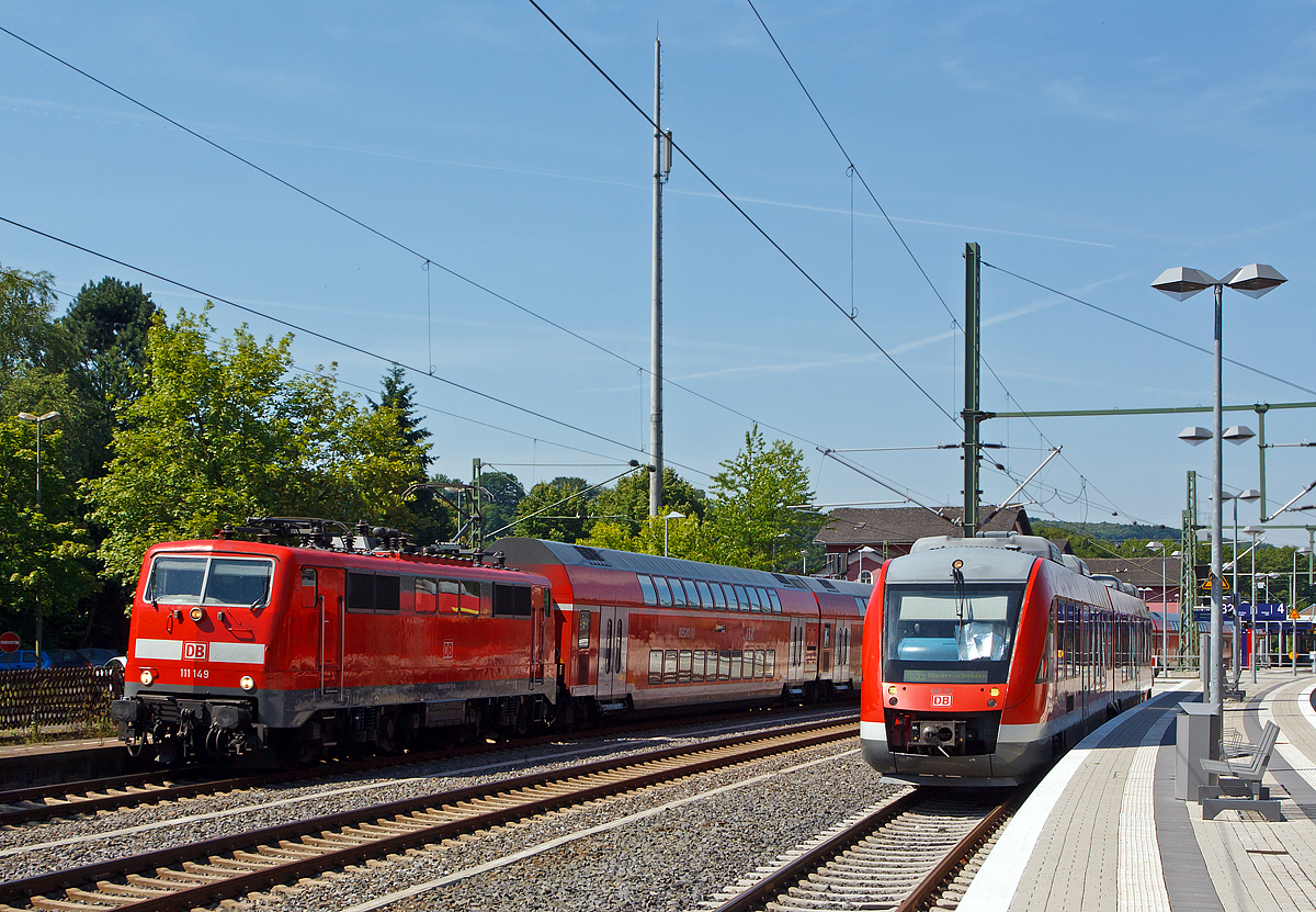 Da hat wohl wieder eine 120.2 die Grätsche gemacht...
So fährt am 19.07.2014 die 111 149-1 der DB Regio NRW mit sechs Doppelstockwagen als RE 9  rsx - Rhein-Sieg-Express   Aachen- Köln - Niederschelden (Umlauf RE 10909), mit zehnminutiger Verspätung vom Bahnhof Au (Sieg) weiter in Richtung Betzdorf. Die Umläufe mit den sechs Dosto´s werden, bedingt durch die besseren fahrdynamischen Werte, eigentlich mit Loks der BR 120.2 gefahren.

Links steht der Dieseltriebwagen 648 201 /648 701, ein Alstom Coradia LINT 41 der DreiLänderBahn (DB Regio NRW), als RB 95 nach Niederschelden zur Abfahrt bereit. Bis Mitte August 2014 ist in Niederschelden Endstation, der Grund dafür ist der Weiterbau der Hüttentalstraße (HTS) als B 62. Diese Hochstraße überquert in Niederschelden die Siegstrecke (KBS 460). 