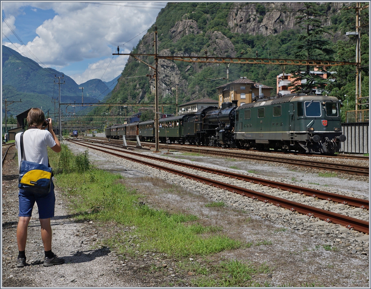 Da die Re 4/4 II 11161 über ETCS verfügt und grün ist, wird sie gerne als ETCS Vorspannlok bei historischen Zügen eingesetzt, so auch hier in Bodio wo die Lok dem Dampfzug für die Weiterfahrt nach Bellinzona vorgespannt wird. 
(Der (bekannte) Fotograf links im Bild habe ich absichtlich mit ins Bild genommen. 

28. Juli 2016