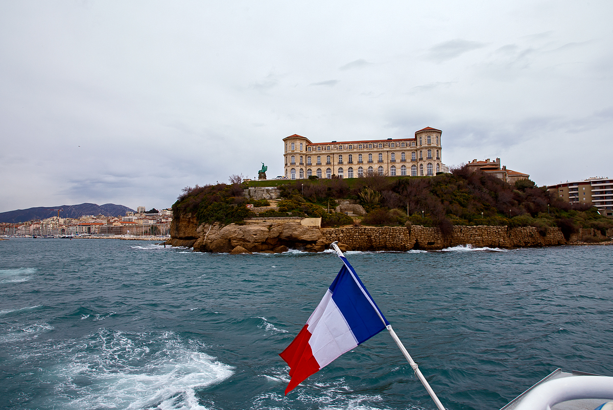 Das Palais du Pharo in Marseille am 25.03.2015 von der Seeseite.

Der Palast wurde ab 1858 von Napoleon III. (Geburtsnamen Charles-Louis-Napoléon Bonaparte) für seine Frau Eugénie de Montijo erbaut. Napoleon III. war von 1852 bis 1870 Kaiser der Franzosen, er war der Neffe von Napoleons I. (Napoleon Bonaparte).Napoleon der III. hatte übrigens 1867 die Annexion Luxemburgs geplant die aber ja bekanntlich scheiterte.

Das Palais liegt gegenüber dem Fort Saint-Jean mit Blick auf den Hafen und der Bucht von Marseille. Beim Sturz von Napoleon III. im Jahr 1870 war der Palast nach zwölf Jahre Bauzeit noch nicht fertiggestellt, so hat das Kaiserpaar dort nie gelebt.

Nach dem Sturz des Regimes griffen Gegner Napoleons III. Symbole des Imperiums an; insbesondere zerstörte die Menge napoleonischen Embleme und Ornamente, die die Fassade des Gebäudes schmückten.

Als der ehemalige Kaiser 1973 starb, reichte die Stadt Marseille Klage gegen die ehemalige Kaiserin ein. Dies führt zu einem Prozess, an dessen Ende Eugenie 1884 beschloss, das Schloss und seine Gärten der Stadt anzubieten, sofern sie für gemeinnützige Zwecke genutzt werden.
