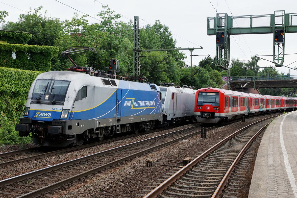 DB/MWB: Die 182 911-8 der Mittelweserbahn anlässlich einer seltenen Begegnung vom 9. August 2016 mit einer S-Bahn in Hamburg Harburg.
Foto: Walter Ruetsch