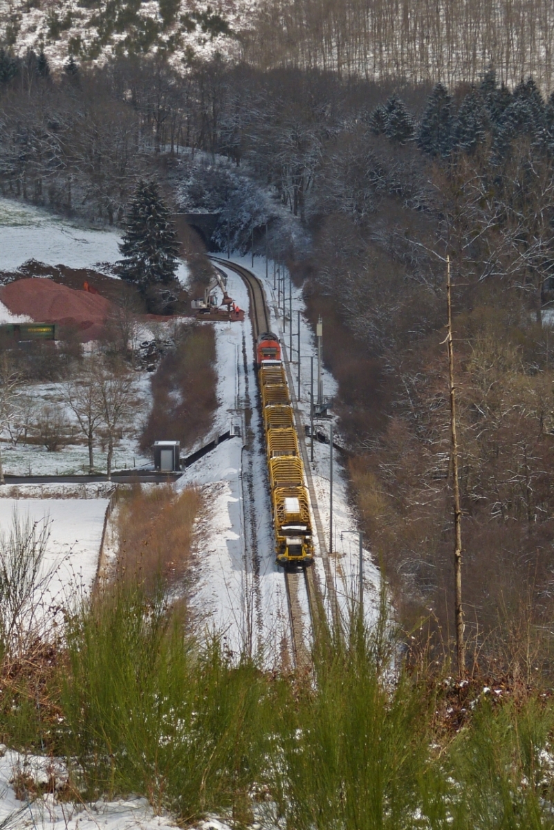 Den versuch die Länge des Gleisumbauzuges in einem Bild festzuhalten kann ich vergessen,  Lok 2016 906 fährt mit 6 vollbeladenen Siloschotterwagen an Mecher in Richtung Clervaux um diese zu entladen. Bild aufgenommen von der Strasse Mecher – Weicherdange über dem Tunnel. 06.04.2021