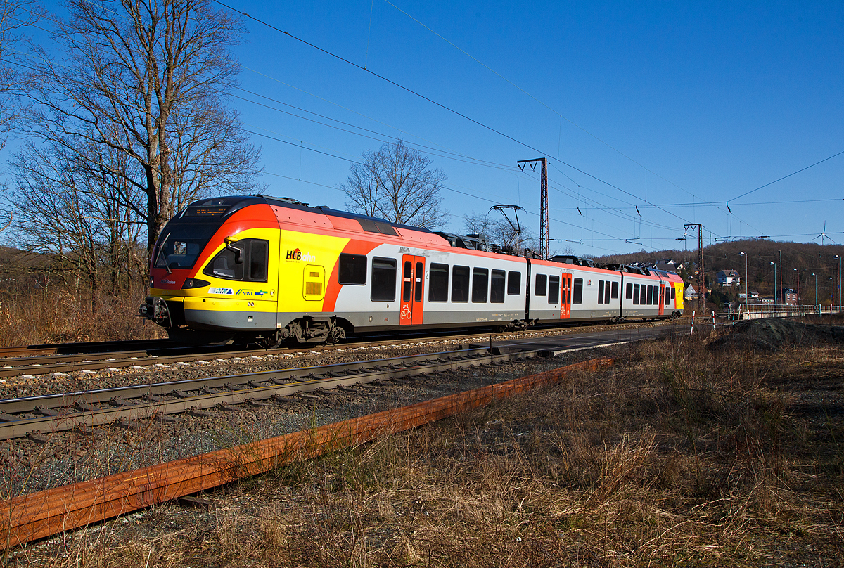 Der 3-teilige Stadler FLIRT 427 541 / 827 041/ 427 041 (94 80 0427 623-4 D-HEB / 94 80 0827 123-1 D-HEB / 94 80 0427 123-5 D-HEB) der HLB Bahn (Hessischen Landesbahn) verlässt am 09.03.2022, als RE 99 (Gießen – Siegen),  den Hp Rudersdorf (Kr. Siegen)  und fährt weiter in Richtung Siegen. 

Nochmals einen lieben Grüß an den netten Tf zurück.

Der Triebzug wurde 2010 von Stadler Pankow in Berlin unter den Fabriknummern 38620, 38621 und 38622 gebaut und an die HLB geliefert.