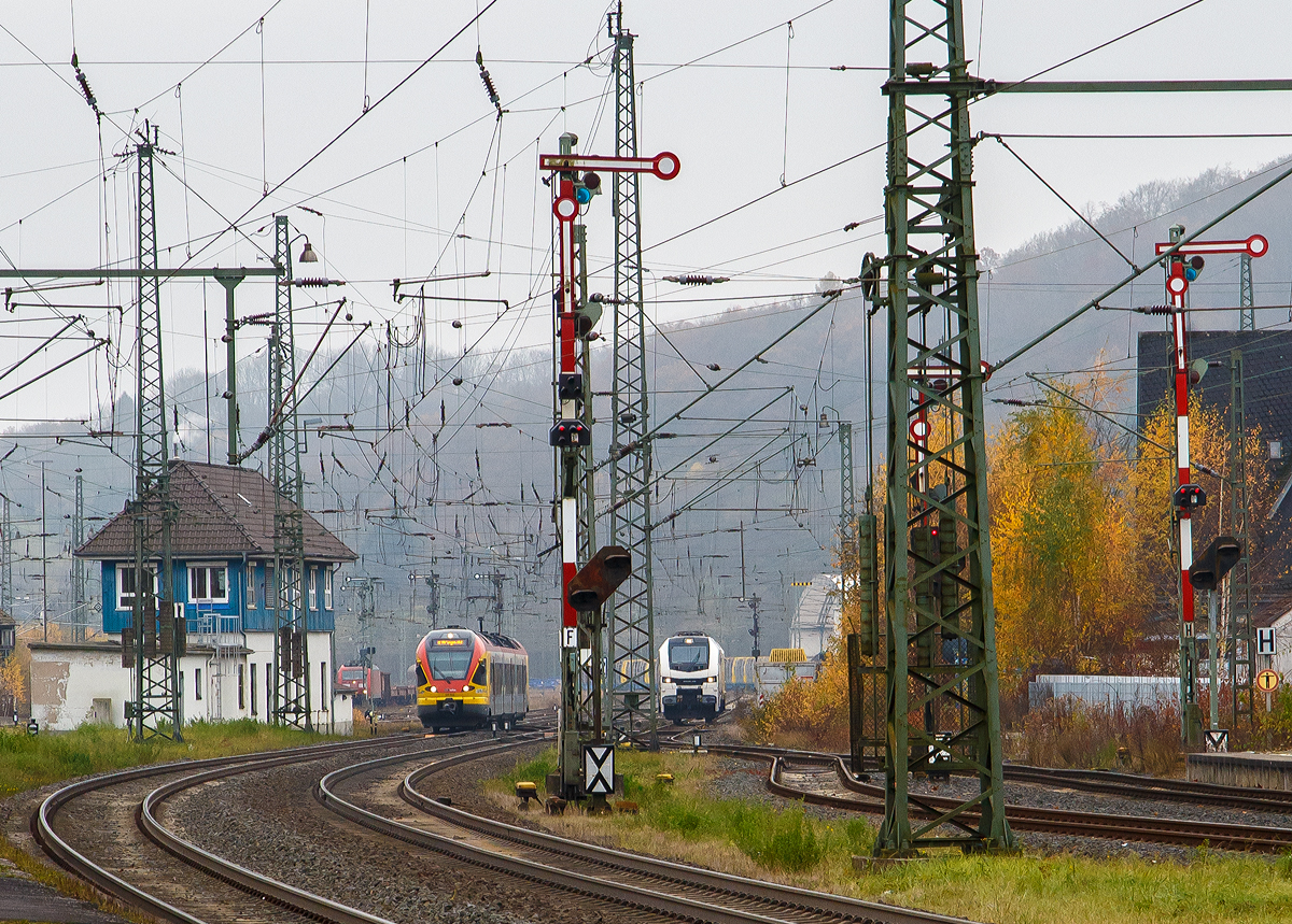 Der Bahnhof Dillenburg an dem diesigen 12.11.2021, Blickrichtung Rbf (Süden):
Im Rbf ist z.Z. eine mächtige Holzverladung (Fichtenholz) im Gange. Links das Stellwerk Dillenburg Fahrdienstleiter (Df) , rechts davon kommt gerade 3-teilige Stadler FLIRT 427 042 / 827 042 / 427 542 der HLB Bahn, als RE 99 Gießen – Siegen (unser Zug). In der Bildmitte rangiert gerade eine an die HLG - Holzlogistik und Güterbahn GmbH vermietete Stadler EuroDual 6000 - BR 159.