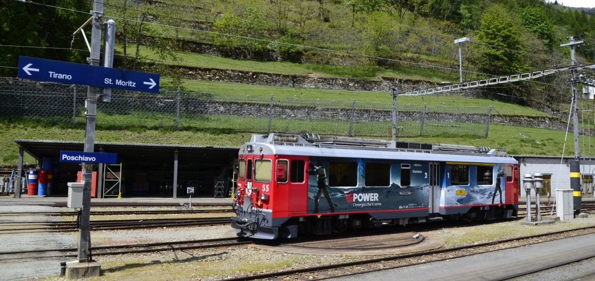 Der Bernina Triebzug ABe 4/4 Nr. 55 mit Werbung fr RE POWER wartet im Bahnhof Poschiavo auf den nchsten Einsatz. Ob es links in Richtung Tirano oder nach rechts in Richtung St. Moritz geht ist nicht bekannt. Jedenfalls kndigt das Lutewerk am rechten Bildrand jede Zugfahrt an. (16.05.2014)
