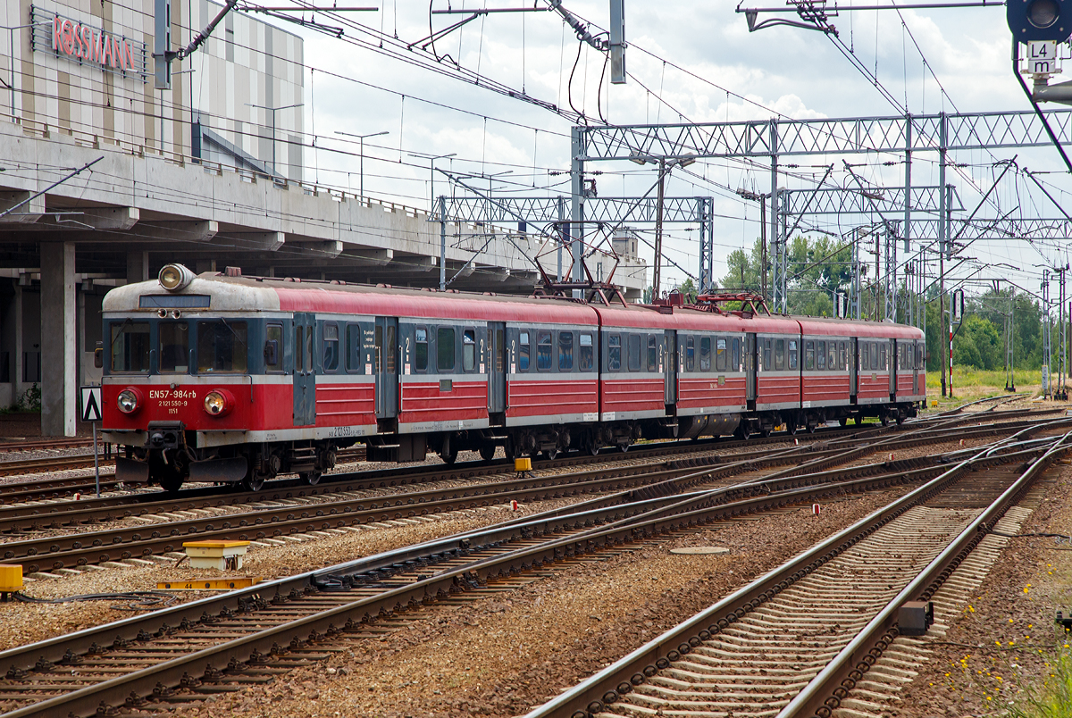 
Der Elektrotriebzug – Elektryczne zespoły trakcyjne EN57-984 (94 51 2 121 550-9 PL-PREG 1151 / 94 51 2 121 549-1 PL-PREG und 94 51 2 121 548-3 PL-PREG) ein Triebzug vom Typ Pafawag 5B/6B der POLREGIO (Przewozy Regionalne Sp. z o.o.) fährt am 25.06.2017 vom Hauptbahnhof Posen (Poznań Główny) in den Abstellbereich. 

Der Triebzug wurde 1974 von PaFaWag in Wrocław unter der Fabriknummer 517 gebaut und als EN57-984 an die PKP geliefert, seit 2009 ist er bei der POLREGIO. Es ist ein Ur EN 57er.

Die Baureihe EN57 ist eine Baureihe dreiteiliger elektrischer Triebwagen ursprünglich der Polnischen Staatsbahnen (PKP). Seitdem der Nahverkehr aus diesen herausgelöst wurde, fahren sie für die jeweilige Nachfolgegesellschaft, hauptsächlich Przewozy Regionalne, teilweise erheblich modernisiert. Dieser ist jedoch noch im Auslieferzustand.

Die Elektrischen-Triebzüge EN57 bestehen aus einer festen Konfiguration von drei Fahrzeugteilen, zwei Steuerwagen (Herstellerbezeichnung 5B) und einem Triebwagen (Herstellerbezeichnung 6A) dazwischen. Scharfenbergkupplungen an den Enden ermöglicht das Zusammenkuppeln mehrerer Triebzüge.

TECHNISCHE DATEN:
Nummerierung (Auslieferzustand): 001–130; 601–1828; 1900–1953
Gebaute Anzahl: 1412
Hersteller: PaFaWag in Wrocław
Baujahre: 1961–1993
Spurweite: 1.435 mm (Normalspur)
Achsformel: 2'2'+Bo'Bo'+2'2'
Länge über Kupplung: 64.970 mm
Breite: 2.880 mm
Höhe: 3.720 mm
Treibraddurchmesser: 1.000 mm
Laufraddurchmesser: 920 mm
Dienstgewicht: 126,5 t
Höchstgeschwindigkeit: 120 km/h (ab der 2. Lieferserie)
Leistung: 4×175 kW (2.Serie)
Stromsystem: 3 kV DC
Anzahl der Fahrmotoren: 4
Kupplungstyp: Scharfenbergkupplung
Sitzplätze: 212
