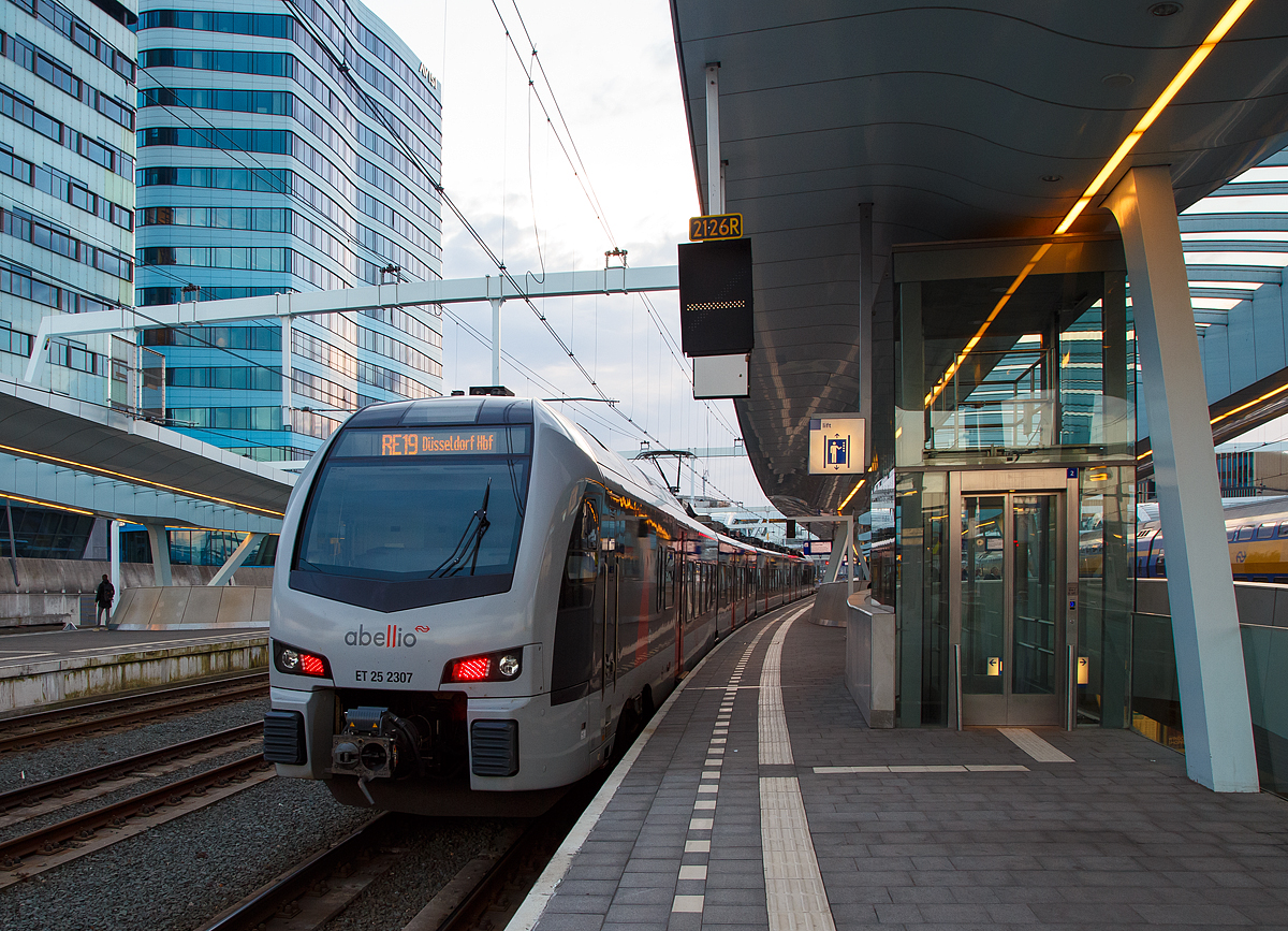 
Der ET 25 2307 ein fünfteiliger Mehrsystem Stadler FLIRT 3 (BR 2429) Abellio Rail NRW steht am 31.03.2018, als RE 19  Rhein-IJssel-Express , im Bahnhof Arnhem Centraal (Arnheim) zur Abfahrt nach Düsseldorf bereit. 

Diese fünfteiligen Stadler FLIRT 3 sind elektrische Mehrsystem-Triebzüge (15 kV/25 kV/1,5 kV) mit Niederlande-Zulassung. Die Abellio Rail NRW hat neun dieser Mehrsystem FLIRT für den Einsatz auf dieser Strecke. Auf der Verbindung gibt es drei Stromsysteme und zwar: 15 kV 16,7 Hz AC von Düsseldorf bis Elten, 25 kV 50 Hz DC von Elten bis Zevenaar (Übergang zur Betuweroute) und 1,5 kV DC von Zevenaar bis Arnhem.