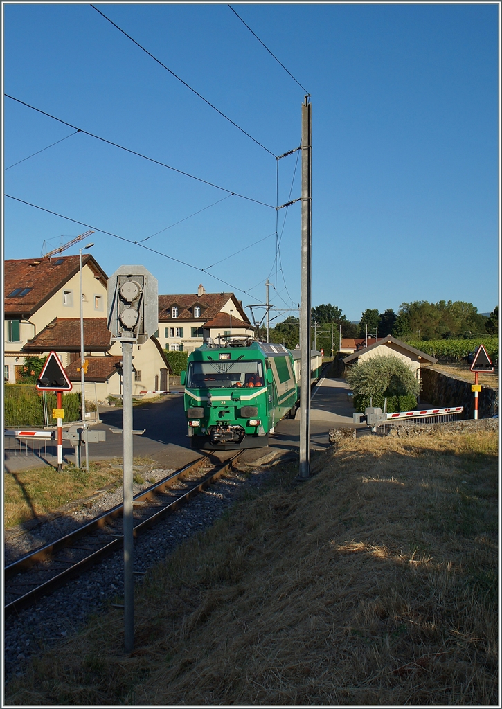 Der von der Ge 4/4 22 gezogen Zug BAM 105 in Vufflens le Château. Einen Monat nach dem höchsten Sonnenstand machten sich unvermutet bereits erste Schatten bemerkbar. 
21. Juli 2015
