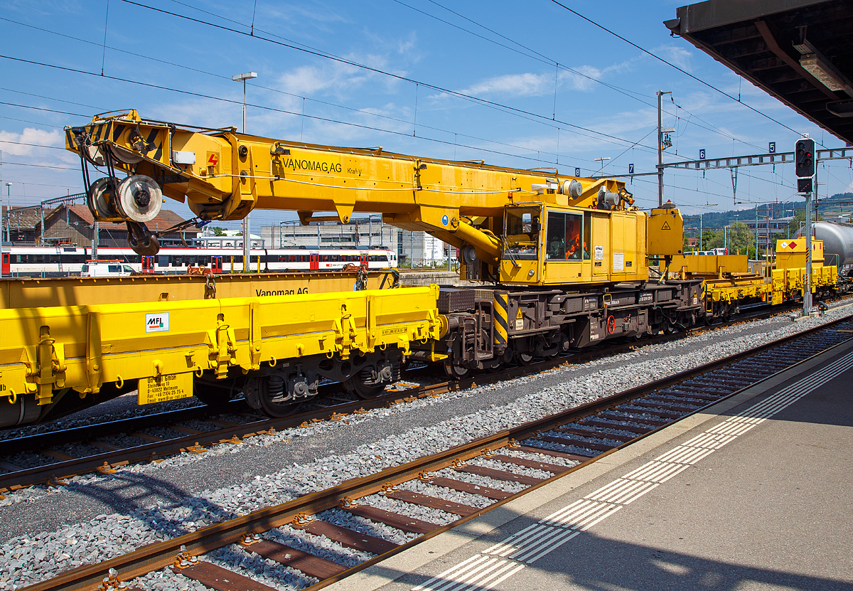 Der Kran V der Vanomag AG ein 100 t GOTTWALD Gleisbauschienenkran GS 80.08 T, 99 85 9219 025-5 CH-VMG VTmaass, ex VTmaass 80 85 95 81 404-3, im Zugverband am 18.05.2018 beim Signalhalt im Bahnhof Yverdon-les-Bains.

Der Kran wurde 1994 von Gottwald in Düsseldorf gebaut.

TECHNISCHE DATEN:
Spurweite: 1.435 mm
Länger über Puffer: 13.000 mm (ohne Kranausleger)
Breite in Transportstellung:  3.100 mm
Höhe in Transportstellung:  4.200 mm
Anzahl der Achsen: 8 (in 4 Drehgestelle bzw. 2 Doppeldrehgestelle)
Drehzapfenabstand: 8.000 mm
Drehzapfenabstand im Doppeldrehgestell: 2.300 mm
Achsabstand in den Einzeldrehgestellen: 1.100 mm
Ergebene Achsabstände in m: 1,1 / 1,2 / 1,1/ 5,6 / 1,1 / 1,2 / 1,1
Raddurchmesser: 730 mm (neu) / 680 mm (abgenutzt)
Eigengewicht (in Transportstellung): 120 t
Maximale Traglast: 100 t (abgestützt)  / 80 t (freistehend)
Kleinster befahrbarer Radius: 90 m 
max. Geschwindigkeit im Zugverband: 120 km/h
max. Geschwindigkeit im Eigenantrieb: 20 km/h
Maximale Achslast (in Transportstellung): 15 t
Motorleistung  190 kW
Maximale Ausladung vor Puffer: 13,5 m (Traglast 30 t)