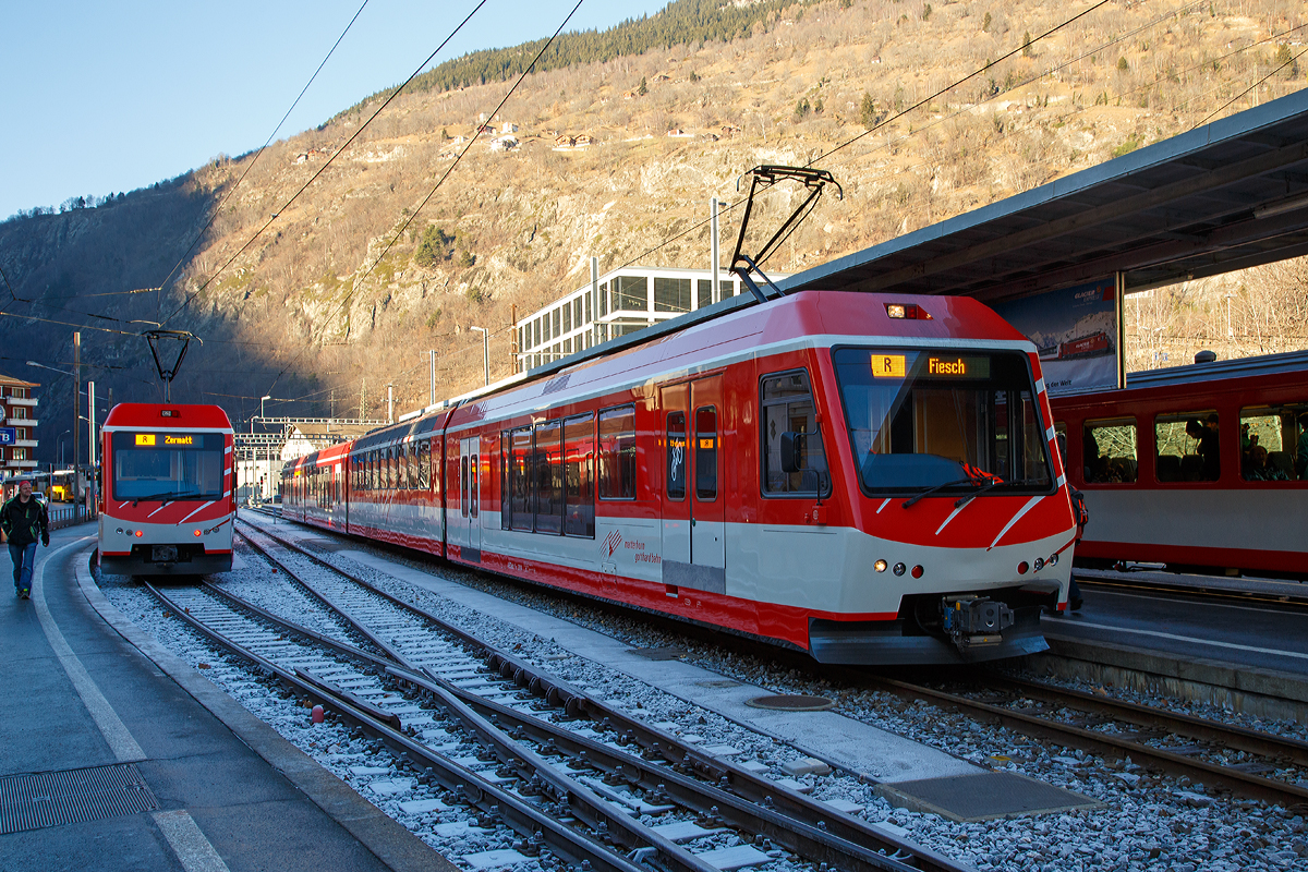 
Der MGB ABDeh 4/10 „KOMET“ ein Stadler Niederflur-Panoramatriebzug mit Zahnrad- und Adhsionsantrieb steht am 30.12.2015 als Regionalzug im Bahnhof  Brig (Bahnhofsvorplatz) zur Abfahrt nach Fiesch bereit. Whrend links zwei gekuppelte (dreiteilige) MGB ABDeh 4/8 „KOMET“ als Regionalzug zur Abfahrt nach Zermatt bereit stehen. 

Diese Triebzge, wie auch der BDSeh 4/8 sind von Stadler gebaute elektrische Schmalspur-Niederflur-Panoramatriebzge, das Krzel „KOMET“ steht fr „KOmfortabler MEterspur-Triebzug“. 

Der ABDeh 4/10 ist ein vierteiliger Triebzug mit 1. und 2. Klasseabteil, der ABDeh 4/8 ist ein dreiteiliger Triebzug mit 1. und 2. Klasseabteil und der BDSeh 4/8 ist ein dreiteiliger Triebzug dieser hat kein 1. Klasseabteil, besitzt aber einen groen Gepckbereich fr bis zu 36 Kofferkulis, diese knnen ber Klapptritte eben in die beiden Endwagen geschoben werden. Die BDSeh 4/8 sind meist im Pendelverkehr zwischen dem autofreien Zermatt und dem Autoparkplatz in Tsch im Einsatz, whrend die ABDeh 4/10 und ABDeh 4/8 auf dem ganzen Stammnetz der MGBahn unterwegs sind. Der vierteilige ist jedoch nicht fr grere Steigungen (Maximalsteigung 179 Promille) aufweisende Schllenenbahn Andermatt–Gschenen zugelassen, der dreiteilige Varianten haben diese Zulassung.

Jeder Triebzug besteht aus einem hochflurigen, einstiegslosen, vierachsigen Triebwagen, auf den auf einer Seite ein und auf der anderen Seite ein bzw. zwei (beim ABDeh 4/10) antriebslose Elemente mit Niederflureinstiegen aufgesattelt sind. Der Triebwagen verfgt ber zwei zweiachsige Drehgestelle mit je einem Fahrmotor pro Achse. Der Antrieb erfolgt im reinen Adhsionsbetrieb ber die acht Rder der Triebdrehgestelle und im Zahnradbetrieb zustzlich ber vier Zahnrder fr die bei der MGB verwendete Zahnstangen Systems Abt. Die aufgesattelten Elemente besitzen jeweils nur ein Lauf-/Bremsdrehgestell am ueren Wagenende und sttzen sich am anderen Ende auf den nchsten Wagen auf. Alle Drehgestelle sind luftgefedert. Die hochflurigen Bereiche des Triebzuges verfgen ber Panoramafenster. 

Dank einer automatischen Mittelpufferkupplung vom Typ FK (Schwab FK-9-6) knnen die Triebzge in Mehrfachtraktion der unterschiedlichen KOMETen und den passenden Steuerwagen (Niederflur-Gelenksteuerwagen ABt 2131–34 und Gepck-Steuerwagen BDkt 2231–33) fahren, was eine Anpassung an die Kapazittsbedrfnisse ermglicht.


TECHNISCHE DATEN des ABDeh 4/10:
Anzahl Fahrzeuge: 4 Stck (Nummer 2011-2014)
Spurweite:  1.000 mm
Achsanordnung: 2‘Bo‘Bo‘2‘2
Lnge ber Kupplung: 74.728 mm
Fahrzeugbreite:  2.650 mm
Fahrzeughhe: 3.950 mm
Dienstgewicht, tara: 95,0 t
Achsabstand Triebdrehgestell: 2.540 mm
Lauf-/Bremsdrehgestell: 1.800 mm
Triebraddurchmesser (neu): 796 mm
Laufraddurchmesser (neu): 685 mm
Fubodenhhe Niederflurbereiche: 415 mm
Fubodenhhe Hochflurbereiche: 950 mm bzw. 1100 mm
Einstiegbreite: 1.600 mm
Sitzpltze: 1. Klasse 47 / 2. Klasse 141 
Dauerleistung am Rad: 1.000 kW
Max Leistung am Rad: 1.300 kW
Anfahrzugskraft: 200 kN
Hchstgeschwindigkeit:  80 km/h (Adhsion) / 40 km/h (Zahnrad)
Zahnradsystem: 	Abt (2 Lamellen)
Anzahl Antriebszahnrder: 4
Speisespannung: 11 kV, 16.7 Hz

Abweichende  DATEN des ABDeh 4/8:
Anzahl Fahrzeuge: 8 Stck (Nummer 2021-2028)
Achsanordnung: 2‘Bo‘Bo‘2‘
Lnge ber Kupplung: 56.664 mm
Dienstgewicht, tara: 77,0 t
Sitzpltze: 1. Klasse 30 / 2. Klasse 114

Abweichende  DATEN des BDSeh 4/8:
Anzahl Fahrzeuge: 4 Stck (Nummer 2051-2054)
Achsanordnung: 2‘Bo‘Bo‘2‘
Lnge ber Kupplung: 52.014 mm
Dienstgewicht, tara: 71,8 t
Sitzpltze: 120 (2. Klasse)
Pltze fr Gepckrolli: 36
Anfahrzugskraft: 180 kN

Quellen: Stadler Rail und Wikipedia
