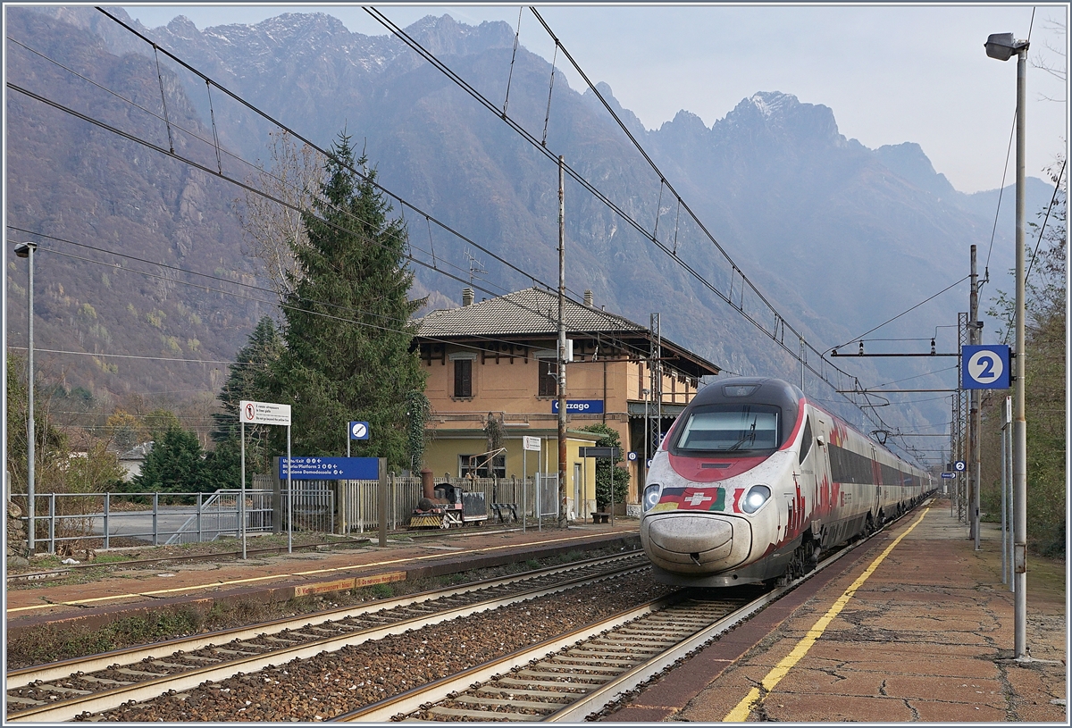Der SBB RABe 503 022-7  Johann Wolfgang von Goethe  fährt als EC 151 von Milano nach Frankfurt durch den Bahnhof von Cuzzago Richtung Domodossola, welches in gut einer viertel Stunde erreicht wird. Auf dem Bahnsteig 1 wartet eine kleine Dampflok vergeblich auf die Weiterfahrt. 
29. Nov. 2018