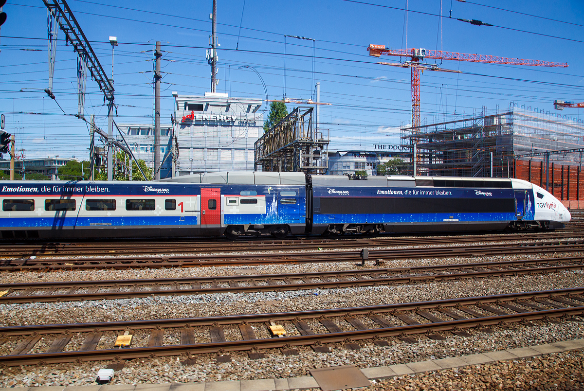 
Der TGV Lyria 4405  Disneyland Paris  (TGV 384009), ex TGV POS 4405, am 01.08.2019 beim Bahnhof Zürich HB. Aufgenommen aus einem ausfahrenden Zug heraus. 

Lyria ist eine Tochtergesellschaft der Société nationale des chemins de fer français (SNCF) und der Schweizerischen Bundesbahnen (SBB), welche die TGV-Verbindungen zwischen Frankreich und der Schweiz betreiben. An der Gesellschaft nach französischem Recht und mit Sitz in Paris hält die SNCF 74 % der Anteile, die SBB 26 %.
POS steht für Paris-Ostfrankreich-Süddeutschland.
Ab 2011 übernahm Lyria die 19 existierenden TGV POS, die zuvor für Alleo nach Süddeutschland fuhren. Die Züge erhielten eine neue Lackierung mit Lyria-Logo und wurden bis 2015 innen modernisiert. Seit 2012 verkehrten auf der Strecke Paris–Basel(–Zürich).