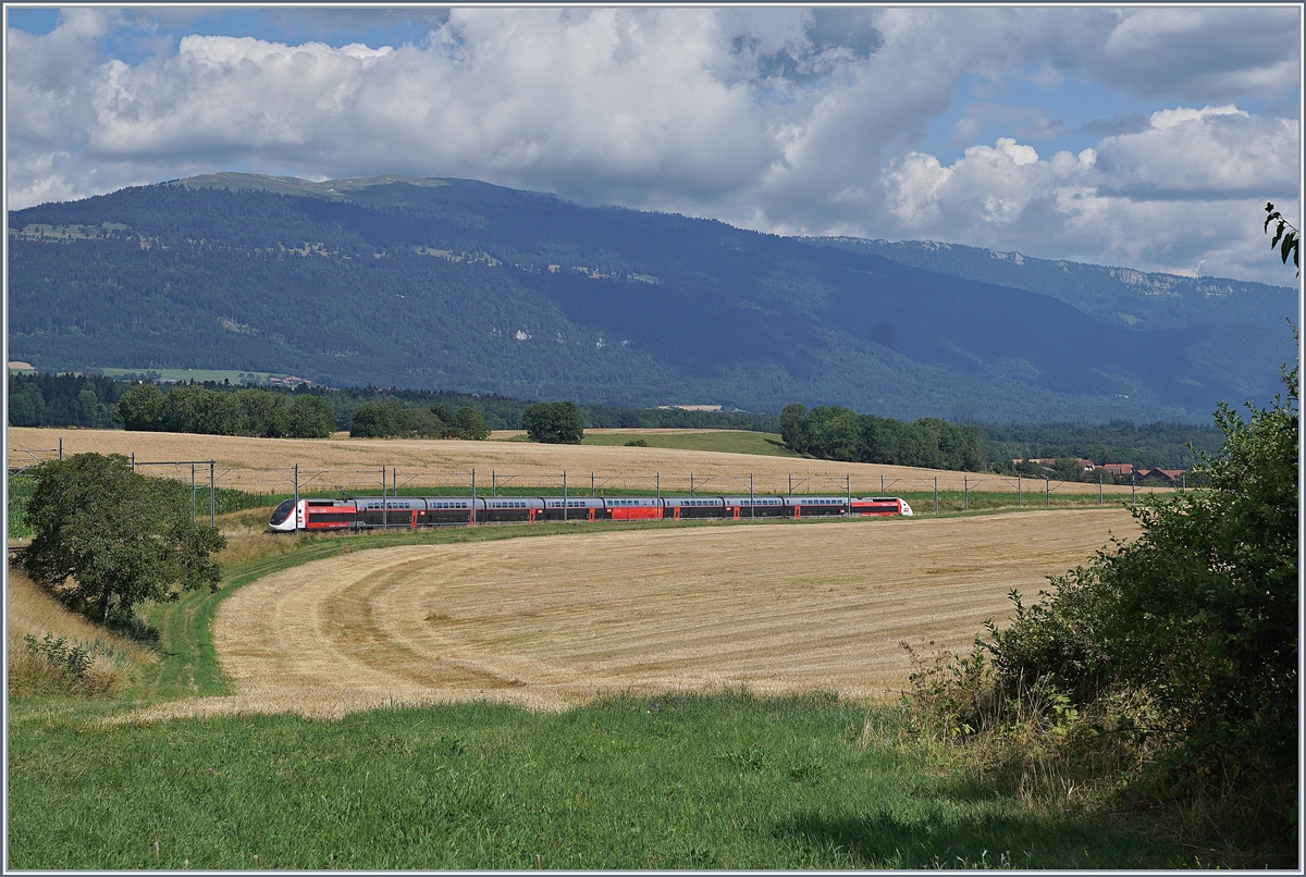 Der TGV Lyria 9261 von Paris Gare de Lyon nach Lausanne oberhalb von Arnex auf der Fahrt durch die hügligen Jurasüdfuss Landschaft. 

25. Juli 2020