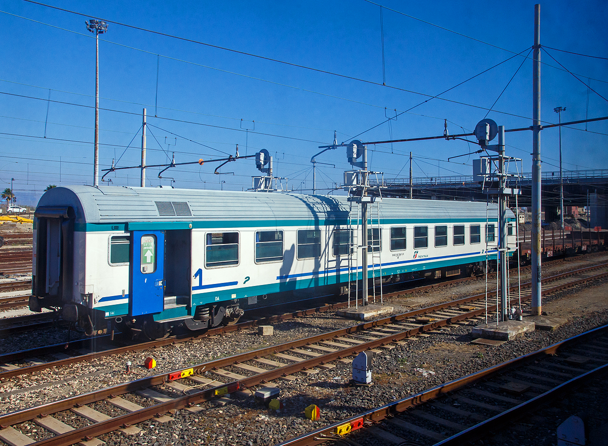 Der Trenitalia 2. Klasse MDVC-Reisezugwagen 50 83 21-87 780-7 I-TI der Gattung nB, am 20.07.2022 im Bahnhof Messina Centrale als Schutzwagen für das Trajekt-Manöver, vor der D.145.2037 und zwei Flachwagen.