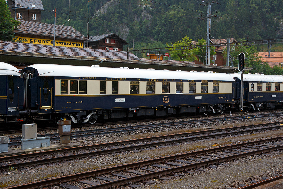 
Der VSOE Pullman Barwagen Nr. 3674 (F- VSOE 61 87 09-70 674-0) im Zugverbund vom Venice Simplon-Orient-Express am 02.08.2019 beim Halt in Göschenen (CH), leider bei Regen.

Der Pullmanwagen (Bar) wurde 1930 von Entreprises industrielles des Charentes (EIC, heute zu Alstom gehörend) in Aytré (F) gebaut. Zwischen 2003 und 2006 wurden die Wagen nochmals modernisiert und erhielten unter anderem moderne Drehgestelle von Bombardier sowie neue Klimaanlagen. Seitdem sind die Wagen nun für 160 km/h zugelassen.

TECHNISCHE DATEN:
Spurweite: 1.435 mm (Normalspur)
Anzahl der Achsen: 4 in zwei Drehgestellen
Länge über Puffer: 23.450 mm
Drehzapfenabstand: 17.600 mm
Achsabstand im Drehgestell: 2.500 mm
Eigengewicht: 49 t
Höchstgeschwindigkeit: 160 km/h (ursprünglich 140 km/h)
Sitzplätze: 36
