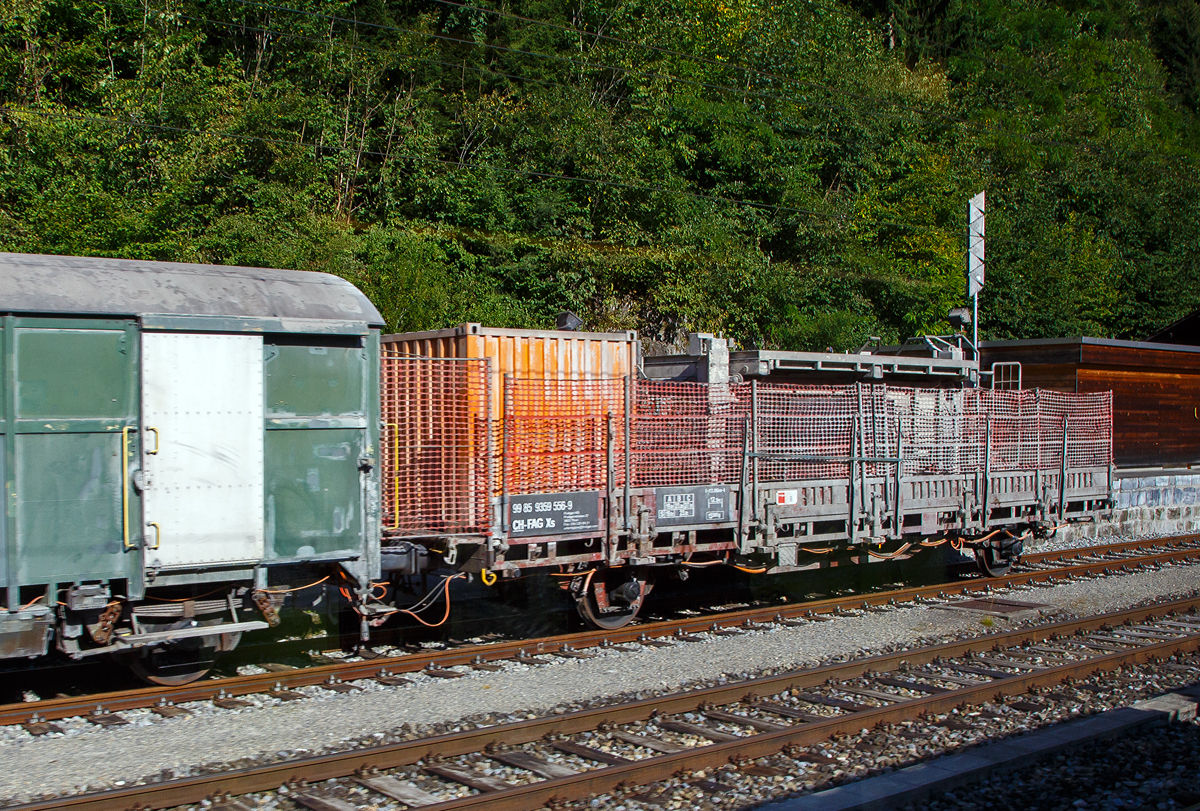 Der zweiachsige Flachwagen mit Seiten- und Stirnwandklappen Xs 99 85 9359 556-9 CH-FAG (Güterwagen Gattung wäre Ks) der Frutiger AG (Thun) abgestellt am 08.09.2021 beim BLS Bahnhof Blausee-Mitholz an der Lötschberg Nordrampe, aufgenommen aus einem Zug heraus.