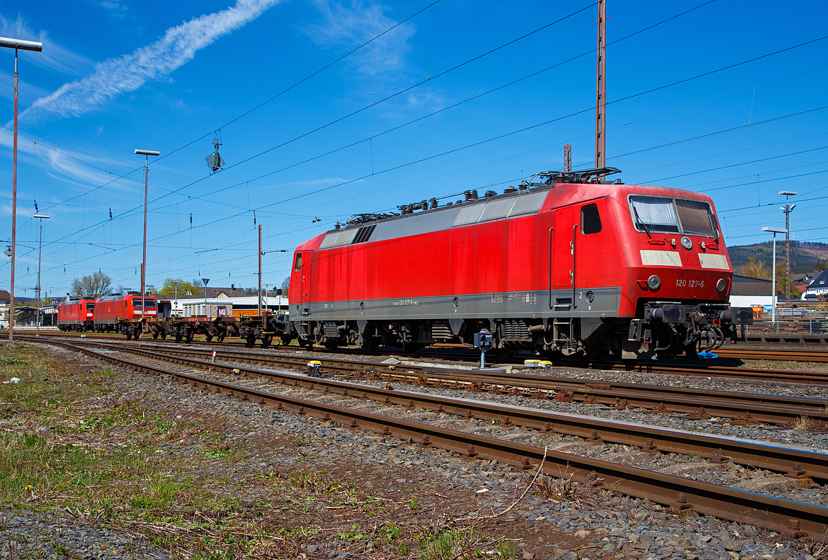 Die 120 127-6 (91 80 6120 127-6 D-BLC) der Bahnlogistik24 GmbH (Dresden) ist am 17.04.2022 in Kreuztal angestellt. Eigentümer der Lok ist die Nürnberger Leasing GmbH (Schwaig).

Die Lok wurde 1987 von Krauss-Maffei in München-Allach unter der Fabriknummer 19958 (die elektrische Ausrüstung ist von Siemens) gebaut DB geliefert. Bis 2021 war sie im Bestand der DB Fernverkehr AG, nun fährt sie für die Bahnlogistik24 GmbH (BLC), wobei Eigentümer der Lok ist die Nürnberger Leasing GmbH (Schwaig).

Eigentlich beträgt die Höchstgeschwindigkeit dieser Baureihe 200 km/h (als BR 120.2 160 km/h), bei dieser konnte ich sehen das sie nur für 140 km/h noch zugelassen ist.

Die Baureihe 120 ist eine Elektro-Lokomotivbaureihe der Deutschen Bahn AG. Sie gilt als die weltweit erste in Serie gebaute Drehstrom-Lokomotive im Hochleistungsbereich mit Umrichter in Halbleitertechnik und ist ein Meilenstein in der Entwicklung elektrischer Lokomotiven. Sie repräsentierte zu ihrer Zeit den letzten Stand der Entwicklung des Drehstromantriebs, bei dem aus dem Wechselstrom der Fahrleitung in Traktionsstromrichtern der Drehstrom zum Antrieb der Asynchron-Fahrmotoren gewonnen wird. Ausgehend von der Technologie der Baureihe 120 wurden Mitte der 1980er Jahre die ersten ICE-Triebköpfe entwickelt. Bis 2020 wurden fast alle sich noch im Einsatz befindlichen Loks der Baureihe 120 abgestellt, wie dies bereits 2019.

Die Serienlok BR 120.1:
Nach vierjähriger Erprobung wurden 1984 insgesamt 60 Serienlokomotiven der Baureihe 120.1 zu einem Stückpreis von 5,5 Millionen D-Mark bestellt.

Die technischen Änderungen im Vergleich zu den Prototypen waren gering, so entfiel beispielsweise die als Rückfallebene eingebaute elektrische Widerstandsbremse, da sich die Nutzbremse entgegen ersten Erwartungen als zuverlässig herausgestellt hatte. Dafür erhielten die Lokomotiven einen zusätzlichen Hochspannungsfilter, der zwei zusätzliche Dachleitungen erforderlich machte. Diese wurden bei den Vorserienlokomotiven nachgerüstet. Kritisch betrachtet, wurden die mechanischen Schwächen der Vorserienmodelle der Baureihe 120.0 ebenfalls in der Serie beibehalten. Nach erfolgreichen Versuchen mit den für maximal 160 km/h zugelassenen Prototypen 120 001 bis 004 und der bereits für 200 km/h zugelassenen 120 005 konnten die Serienloks für bis zu 200 km/h zugelassen werden.

Am 13. Januar 1987 übergab die Industrie im Bundesbahn-Ausbesserungswerk München-Freimann mit der 120 103 die erste Serien-Drehstromlokomotive an die damalige Deutsche Bundesbahn. Die Auslieferung der Serienloks dauerte bis Ende des Jahres 1989. Sie wurden sofort im planmäßigen Dienst eingesetzt, wobei sie in einem gestrafften Umlaufplan tagsüber Intercity- und Interregio-Züge und nachts schnelle Güterzüge bespannten.

Ausmusterung:
Durch den technischen Fortschritt im Bereich der Schienenfahrzeugtechnik gilt die Baureihe 120 mittlerweile als überholt und zeigt sich zunehmend störanfällig. Der Betriebsbestand der Serienmaschinen bei der DB ist stetig rückläufig. Erste Serienlokomotiven sind bereits verschrottet. Andere Lokomotiven wurden verkauft, wie auch diese hier.

TECHNISCHE DATEN:
Spurweite: 1.435 mm,
Achsformel: Bo`Bo`
Länge über Puffer: 19.200 mm
Drehzapfenabstand: 10.200 mm
Achsabstand im Drehgestell: 2.800 mm
Treibraddurchmesser: 1.250 mm (neu)
Dienstgewicht: 83,2 t
Anzahl der Fahrmotoren: 4
Dauerleistung: 5.600 kW (4 x 1.400 kW)
Anfahrzugkraft: 340 kN (20 137 bis 120 160 nur 290 kN)
Höchstgeschwindigkeit: 200 km/h (als BR 120.2 160 km/h)
Fahrmotoren: 4 Drehstrom-Asynchron-Motoren
Antrieb: Hohlwellen-Kardan-Einzelachsantrieb 