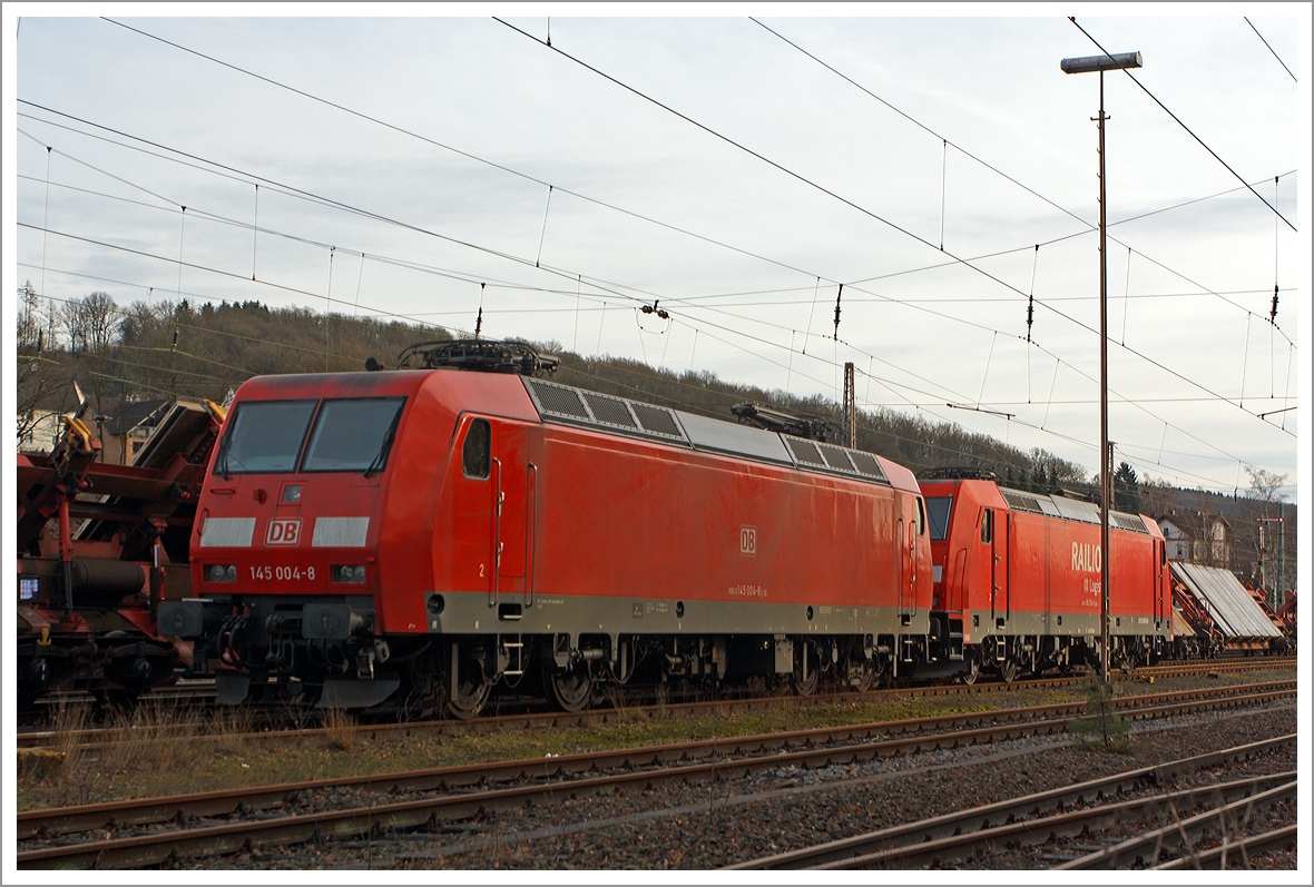 Die 145 004-8 der DB Schenker Rail Deutschland abgestellt am 21.12.2013 in Kreuztal. 

Die TRAXX  F140 AC wurde 1997 bei Adtranz in Kassel unter der Fabriknummer 22298 gebaut, sie hat die NVR-Nummer 91 80 6145 004-8 D-DB und die EBA-Nummer EBA 95T14A 004. 

Dahinter steht die 185 254-0 so kann man gut die Unterschiede zwischen der TRAXX  F140 AC und der F140 AC2 sehen.