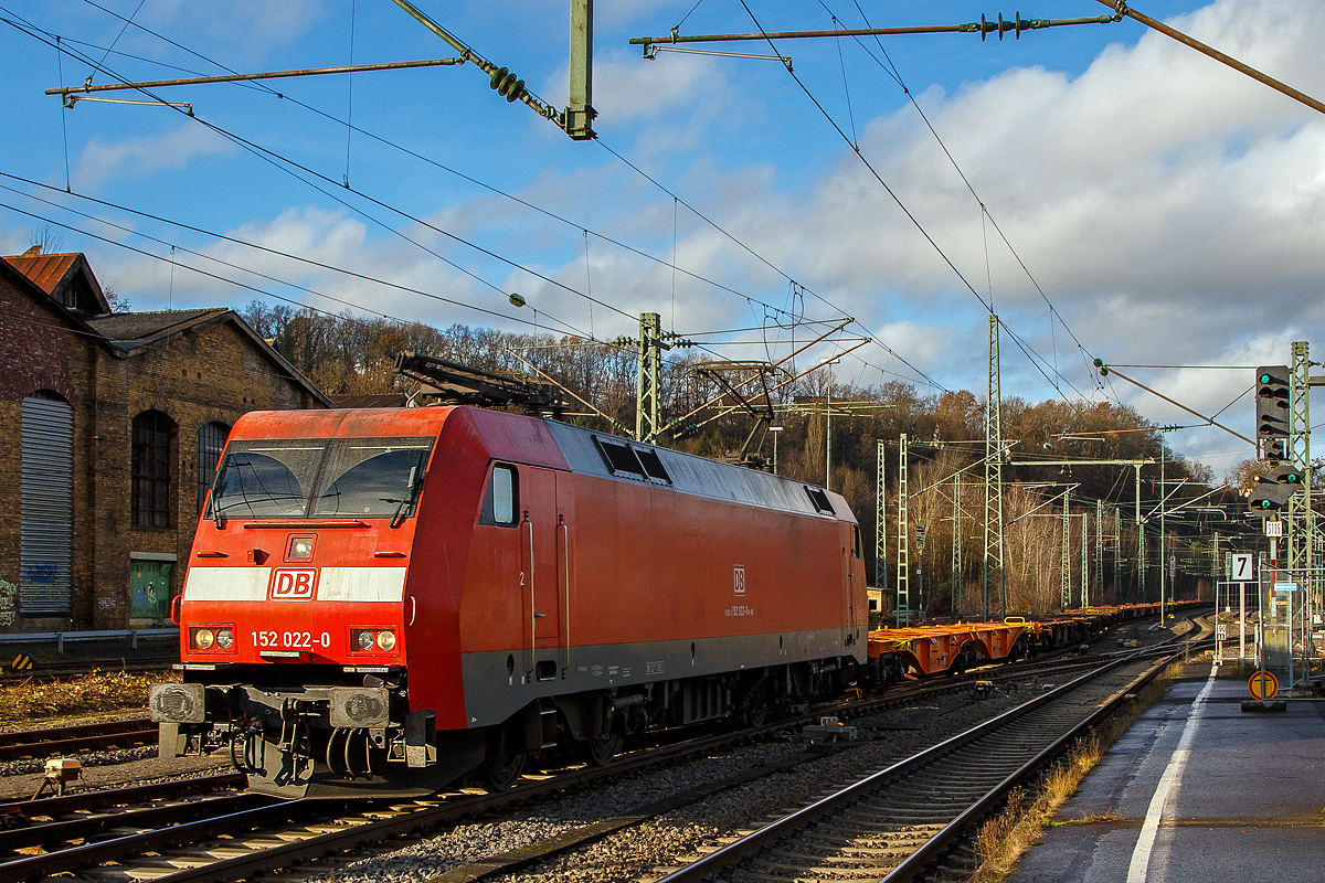 Die 152 022-0 (91 80 6152 022-0 D-DB) der DB Cargo AG fährt am 16.12.2020 mit einen Leerzug von Containertragwagen (u.a. der Gattung Sgns, Sggrs und Sggmrs), durch den Bahnhof (Sieg) in Richtung Siegen.

Die Siemens ES64F wurde1998 noch von Krauss-Maffei unter der Fabriknummer 20149 für die Deutsche Bahn AG gebaut.

Die DB Baureihe 152 (Siemens ES64F):
Für den Güterverkehr benötigte die Deutsche Bahn Mitte der 1990er-Jahre dringend neue leistungsstarke Lokomotiven. Als Teil des  großen Beschaffungsprogramms für Triebfahrzeuge  der Deutschen Bahn AG wurde nach einer im Jahr 1993 erfolgten Ausschreibung über drei Lokomotivbaureihen 1995 ein Vertrag zwischen DB AG und Krauss-Maffei Verkehrstechnik GmbH (mit dem Partner Siemens) über die Lieferung von 195 Güterzuglokomotiven der oberen Leistungsklasse der Baureihe 152 geschlossen. Der Vertrag beinhaltet eine Option über 100 weitere Lokomotiven, die in direktem Anschluss an die erste Serie zu liefern wären, d. h. in den Jahren 2001 bis 2003.

Technische Basis des Angebots und des Vertrags war die gemeinsam von Krauss-Maffei und Siemens entwickelte EuroSprinter-Familie. Aufgrund des modularen Konzepts der EuroSprinter-Familie und der positiven Betriebserfahrungen in Spanien, Portugal und in Deutschland konnten die technischen Verhandlungen, ausgehend vom funktionalen Lastenheft der DB AG, sehr zielstrebig und effizient geführt werden.

Bei Bau und Entwicklung der neuen Lokomotiven wurde auf neueste Erkenntnisse der Technik Rücksicht genommen. Der Führerstand verfügt über eine Klimaanlage und sogar ein Getränke-Kühlfach für den Lokomotivführer. Zur besseren Sicht bei Dunkelheit wurden, wie auch bei der Baureihe 101, Fernscheinwerfer eingebaut. Interessant sind bei diesen Lokomotiven auch die außen liegenden Scheibenbremsen. Zum Schutz der Umwelt wurden umweltverträgliche Kühlmittel und Lacke auf Wasserbasis verwendet. Die Baureihe 152 hat sich seitdem sehr gut bewährt und läuft, im Gegensatz zur 101, auch weitgehend störungsfrei.

Die ersten vier Lokomotiven wurden bereits 1997 in Betrieb genommen und mit Zulassung des Eisenbahn-Bundesamtes (EBA) geliefert. Ab 1998 lief die Serienlieferung planmäßig. Die ersten zehn Lokomotiven wurden seit dem Fahrplanwechsel im Mai 1998 in einem zehntägigen Umlauf Padborg - Basel eingebunden. Sie zeigten bisher keine Auffälligkeiten und arbeiten zur Zufriedenheit des Betriebes.

Die Abnahmefahrten erbrachten die Bestätigung, dass die im Lastenheft geforderte Leistungsfähigkeit in den vollen Umfang realisiert wurde. Anlässlich einer Vorführfahrt in Österreich wurde die Leistung sogar auf 7 MW gesteigert. Teilweise wurden schwere Güterzüge mit nur drei Motoren gefahren und in keinem der Fälle wurden die thermischen Grenzwerte der Bauteile erreicht. Bei einer Vorführfahrt durch die Schweiz nach Italien wurde ein 3.200-t-Tonerde-Zug mit über 640 kN Anfahrzugkraft in Doppeltraktion ruckfrei angefahren. Damit konnten die bei der Leistungsauslegung eingebauten Reserven wirkungsvoll nachgewiesen werden.

Die BR 152 ging in den Lokomotivbestand von der DB Cargo AG (zeitweise unter Railion bzw. DB Schenker Rail firmiert) ein und sollte dort in erster Linie die sechsachsigen Lokomotiven der BR 150 bzw. 151 ersetzen. Die Lokomotive kann aber auch im Personenverkehr eingesetzt werden. So ist die BR 152 dank hoher Leistung und Zugkraft z.B. sehr gut für schwere Doppelstockzüge im Wendezugbetrieb geeignet.

Zur Auslieferung aller bestellten 195 Stück der 152er kam es allerdings nicht, da wegen einer geringfügigen Überschreitung der Achslasten bekam die neue Baureihe bei der Österreichischen Bundesbahn (ÖBB) keine Zulassung. Man musste handeln. Die neuen Lokomotiven wurden dringend für den Güterverkehr nach Österreichisch benötigt, für eine weitere Neuentwicklung waren weder Zeit noch Geld vorhanden. So wurde die Bestellung über die letzten 25 Stück der BR152 storniert und in die Zweisystemloks Siemens ES64U2 (baugleich mit ÖBB Reihe 1116 - Zweisystemloks „Taurus“) umgewandelt. Diese Lokomotiven wurden im Jahr 2001 ausgeliefert und sind seitdem als Baureihe 182 bei der DB Cargo AG im Dienst.

Konstruktion:
Die Baureihe basiert auf dem von Siemens konstruierten Prototyp ES64P (127 001). Da jedoch klar war, dass die Maschinen doch ausschließlich im Güterverkehr eingesetzt werden sollten und eine Höchstgeschwindigkeit von 140 km/h als ausreichend angesehen wurde, konnte auf die Verwendung von voll abgefederten Fahrmotoren verzichtet und auf den wesentlich einfacheren und preisgünstigeren Tatzlager-Antrieb zurückgegriffen werden. Dieser gilt durch die Verwendung moderner Drehstrommotoren bei niedrigen Geschwindigkeiten als relativ verschleißarm. Die Kraftübertragung zwischen Wagenkasten und Drehgestellen erfolgt in Maffei-Tradition über kräftig dimensionierte und tief herunterreichende Drehzapfen sowie Flexicoilfedern.

Ansonsten entstand eine moderne Maschine mit Drehstromasynchron-Fahrmotoren und doppelten innenbelüfteten Scheibenbremsen. Eine teilredundante Ausführung von hoch beanspruchten Teilen im Antriebsstrang trägt ganz wesentlich zur hohen Zuverlässigkeit und Verfügbarkeit der Baureihe bei.

Der Haupttransformator ist unterflur zwischen den Drehgestellen angeordnet. Jedes Drehgestell verfügt über eine autarke elektrische Ausrüstung, bestehend aus drei Eingangsgleichrichtern in rückspeisefähiger Vierquadranten-Bauweise, Gleichspannungszwischenkreis und zwei Wechselrichtern (einer je Motor). Dadurch wird erreicht, dass bei Ausfall einer Komponente des Antriebsstrangs nicht das gesamte Drehgestell ausfällt, sondern sich lediglich die verfügbare Zugkraft reduziert. Als Leistungshalbleiter kommen wassergekühlte GTO-Thyristoren zum Einsatz. Die Bremskraft der elektrodynamischen Nutzbremse beträgt 150 kN im Bereich zwischen 10 km/h und 140 km/h.

Die Lokomotiven sind mit Zugsammelschiene für die Energieversorgung von Reisezügen sowie Wendezugsteuerung und Notbremsüberbrückung ausgerüstet, so dass sie auch im schweren Personenzugdienst eingesetzt werden können. Durch die Aufteilung der DB AG und Zuordnung der Loks zum Geschäftsbereich Güterverkehr der DB wurde davon seit Ende der 1990er Jahre kein Gebrauch mehr gemacht.

Der Maschinenraum wird von einem beide Führerstände verbindenden Mittelgang durchzogen. Beidseitig sind an den Außenwänden des Lokkastens die elektrische Ausrüstung, die Druckluft- und Bremsgeräte sowie die umfangreichen Kühleinrichtungen angeordnet. Alle Aggregate sind in Form von separaten, austauschbaren Modulen ausgeführt, die von oben in das Fahrzeug eingebracht werden. Dabei wurde auf möglichst kurze Verbindungen, insbesondere bei den Hauptstromleitungen geachtet. Die Steuerleitungen und die Verrohrung sind in Kanälen unter dem Mittelgang verlegt. Die Steuerungs- und Überwachungsgeräte sind an den beiden Enden des Maschinenraums konzentriert.

Die Führerstandsräume sind klimatisiert, wärme- und schallisoliert und verfügen über ein recht großzügiges Raumangebot. Annehmlichkeiten für den Triebfahrzeugführer sind darüber hinaus ein luftgefederter Sitz und ein Thermofach. Die Lokomotiven sind mit Einheitsführerständen ausgerüstet.

TECHNISCHE DATEN der BR 152 (Siemens ES64F):
Hersteller: Krauss-Maffei bzw. Siemens 
Baujahre: 1996-2001
Gebaute Anzah: 170
Spurweite: 1.435 mm (Normalspur)
Achsformel: Bo´Bo´
Länge über Puffer: 19.580 mm
Drehzapfenabstand: 9.900 mm
Achsstand im Drehgestell: 3.000 mm
Treibraddurchmesser: 1.250 mm (neu) / 1.170 mm (abgenutzt)
Breite: 3.000 mm
Dienstgewicht: 86,7 t
Achslast: 21,75 t
Höchstgeschwindigkeit: 140 km/h
Dauerleistung: 6.400 kW (8.701 PS)
Anfahrzugkraft: 300 kN
Dauerzugkraft: 250 KN
Fahrmotoren: 4 Stück fremdbelüfteten vierpolige Drehstrom-Asynchron-Motoren
Getriebeübersetzung: 3,95:1
Antriebsart: integrierter Tatzlagerantrieb
Stromabnehmer: SSS 87 (Einholm)
Stromsystem: 15 kV, 16 2/3 Hz

Elektrisches Antriebssystem: Wassergekühlte GTO-Stromrichter, 3 netzseitige Eingangsgleichrichter (4QS),
Gleichspannungszwischenkreis, 1 Pulswechselrichter pro Fahrmotor, Einzelachsregelung mit 75% Redundanz-

Steuerungs- und Leittechnik: 2 Zentrale Steuergeräte in SIBAS 32 mit integrierter AFB, ZWG, SIFA und zentraler Diagnose, 1 Farbdisplay und MFA pro Führerstand, LZB 80, Gleit- und Schleuderschutz K-Micro.

Bremsausrüstung: Elektrische Netzbremse, Knorr-Führerbremsventilanlage Typ HSM-MEP, Radscheibenbremse, 4 Federspeicher-Festhaltebremsen

