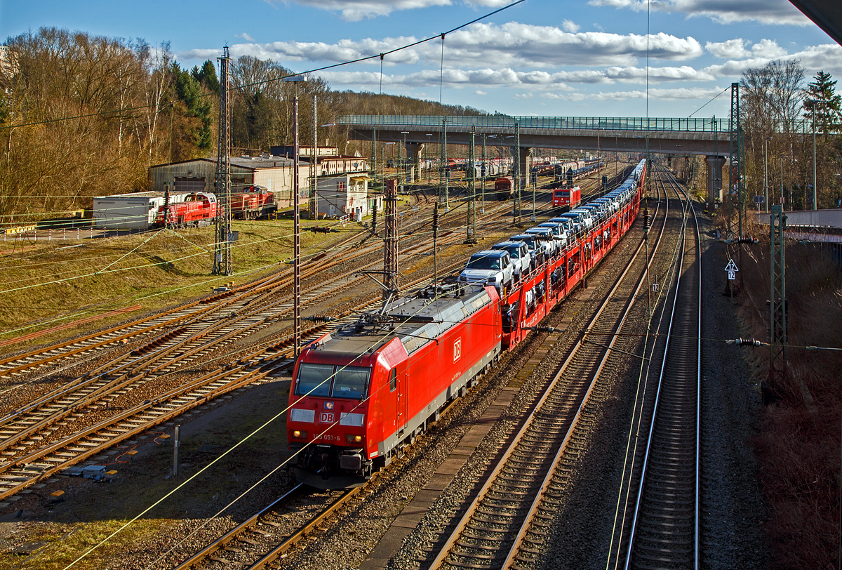 Die 185 053-6 (91 80 6185 053-6 D-DB) der DB Cargo AG, hat am 23.02.2022, mit einem sehr langen Autotransportzug, beim Rbf Kreuztal Hp 0. Der Güterbahnverkehr in Richtung Hagen staute sich etwas in Kreuztal, da die Ruhr-Sieg-Strecke entlang der Lenne (durchs Sauerland) an diesem Tag nur eingleisig befahrbar war. Links der Rangierbahnhof (Rbf) Kreuztal, wo auch u.a. noch die 185 248-2 steht.

Die Wagen von dem Autotransportzug waren Doppelstock-Autotransportwagen der Gattung Laaeffrs 561 (25 80 4382 xxx-x D-ATG) der DB Cargo Logistics GmbH (ex ATG Autotransportlogistic GmbH). 

Die TRAXX F140 AC1 wurde 2002 von Bombardier Transportation GmbH in Kassel unter der Fabriknummer 33461 gebaut.