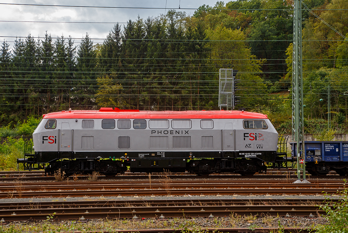 Die 216 121-4 „PHOENIX“ (92 80 1216 121-4 D-FSI) der FSI Logistik GmbH, eine On Rail DH 1504 (umgebaute V 160) ist am 17.09.2022, mit einem Schotterzug (Niederbordwagen der Gattung Eamos), in Betzdorf/Sieg abgestellt.

Die Spenderlok (V 160) wurde 1967 von Deutz (KHD, Kln-Deutz) unter der Fabriknummer 58143 gebaut und an die Deutsche Bundesbahn als V 160 121 geliefert, zum 01.01.1968 erfolgte die Umzeichnung in DB 216 121-4 und im Dezember 1998 erfolgte die Ausmusterung bei der DB und sie ging 2000 an die On Rail Gesellschaft fr Eisenbahnausrstung und Zubehr mbH in Mettmann, welche bei der bei VSFT in Kiel zur heutigen DH 1504/6 umbauen lie. Im Juni 2003 ging die umgebaute Lok dann an die OHE - Osthannoversche Eisenbahnen AG in Celle, wo sie die Betreiberbezeichnung 200095 bekam. Im Jahr 2005 erhielt sie dann die Betreiberbezeichnung OHE 200085 und 2007 die NVR-Nummer 92 80 1216 121-4 D-OHE. Im Jahr 2012 ging sie an die OHE Cargo kam sie 2012 und bekam die NVR-Nummer 92 80 1216 121-4 D-OHEGO. Im August 2022 ging sie an die FSI Logistik GmbH in Bottrop.

Nach einem hnlichen Konzept wie die OnRail DH 1004 wurde fr die Mindener Kreisbahnen eine V 160 umgebaut, wobei von der Spenderlok das Fahrwerk mit Lokkasten und Getriebe verwendet wurde. Ein Ersatz des Lokkastens war nicht mglich, da er als tragendes Teil ausgefhrt ist. Im Inneren der Lok wurden der Dieselmotor, die Fhrerstnde und die gesamten Hilfsbetriebe und Installationen erneuert. An beiden Enden wurden neue Bhnen angebracht, um dem Rangierpersonal, insbesondere bei der Benutzung der ebenfalls neuen Funkfernsteuerung, geeignete Standflchen zu bieten.

Auch diese Type wird von OnRail vertrieben. Whrend der Umbau der ersten beiden Loks (DH 1504/1 und DH 1504/2) als Auftragsarbeit bei VSFT durchgefhrt wurde, entstanden die weiteren vier Loks, wie diese hier im Werk Chemnitz der DB.

TECHNISCHE DATEN:
Spurweite: 1.435 mm (Normalspur)
Achsfolge: B´B´
Lnge ber Puffer: 16.800 mm
Drehzapfenabstand: 8.600 mm
Achsstand im Drehgestell: 2.800 mm
Raddurchmesser neu: 1.000 mm
Dienstgewicht: 80 t
Dieselmotor: MTU 12V4000R20
Dieselmotorleistung: 1.500 kW
Dieselmotordrehzahl: 1.800 U/min
Getriebe: Voith L821rs
Hchstgeschwindigkeit: 120 km/h
Kraftstoffvorrat: 3.800 l
umgebaute Stckzahl: 6

