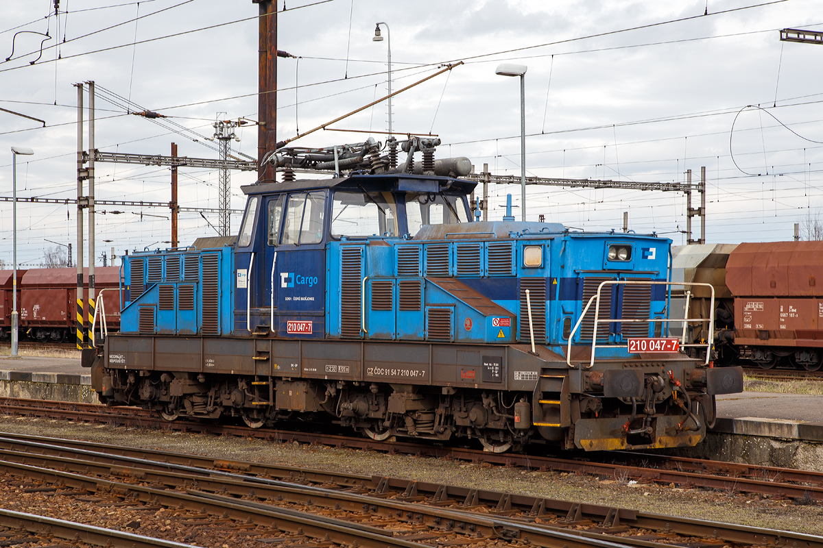 Die ČD Cargo 210 047-7 (CZ ČDC 91 54 7 210 047-7) steht am 28.03.2016 im Bahnhof Cheb.

Die E-Lok wurde 1979 von koda in Plzeň (Pilsen) unter der Fabriknummer 7265 gebaut.

Die ČD Baureihe 210, ex ČSD-Baureihe S 458.0 (ab 1988 Baureihe 210) ist eine elektrische Rangierlokomotive fr 25 kV 50 Hz Wechselstrom.  Sie wurde gleichzeitig mit der Gleichstromlok E 458.0 (heute BR 110) entwickelt, um auf greren Personen- sowie Gterbahnhfen den Verschub sowie die Befrderung von bergabefahrten durchzufhren. Der mechanische Teil ist identisch mit dem der E 458.0, nur im elektrischen Aufbau hat die Lokomotive einen Trafo und eine andere Steuerung. Eine minimale Geschwindigkeit bis zu 5 km/h ist mglich. Die Lokomotiven sind mit einem speziellen Trafo fr die Beheizung des Zuges mit 1,5 kV bzw. 3 kV 50 Hz ausgerstet, und knnen somit auch im Personenzugdienst eingesetzt werden. Das bersetzungsverhltnis zwischen Fahrmotorritzel und Grorad betrgt 1:4,055, was der Lokomotive eine Hchstgeschwindigkeit von 80 km/h ermglicht. Fr den Betrieb auf nicht elektrifizierten Streckenteilen besitzt die Lok Akkumulatoren.

Technische Daten:
Gebaute Stck: 74
Spurweite: 1.435 mm (Normalspur)
Achsformel: Bo’Bo’
Lnge ber Puffer: 14.400 mm
Rahmenlnge:  13.160 mm
Breite: 3.000 mm
Hhe (Pantograph gesenkt):  4.625 mm
Achsstand im Drehgestell : 2.800 mm
Der Gesamt Radstand von 9.600 mm
Drehzapfenabstand:  6. 300 mm
Treibradraddurchmesser: 1.050 mm (neu) / 980 mm (abgenutzt)
Kleister befahrb. Kurvenradius: R = 120 m
Dienstgewicht: 72 t
Max. Achslast : 18 t
Stundenleistung: 984 kW
Dauerleistung: 880 kW
Anfahrzugkraft:  max. 164 kN
Fahrmotoren: 4 Stck Typ TE 006 
Stromsystem: 25 kV 50 Hz AC (Wechselstrom)