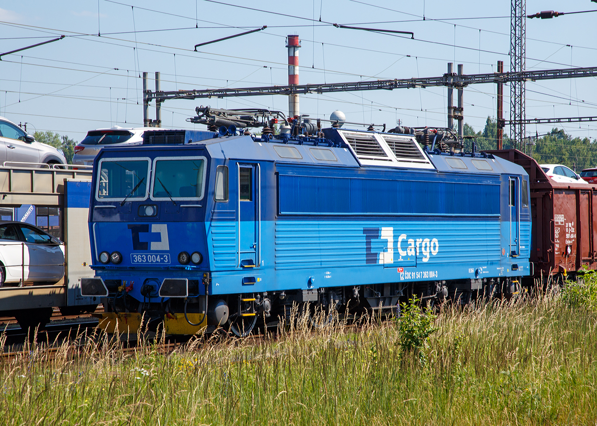 
Die ČD Cargo 363 004-3 (CZ ČDC 91 54 363 004-3) abgestellt mit einem Gterzug am 01.07.2015 beim Bahnhof Cheb (Eger).

Die Lokomotive wurde 1984 von koda in Plzeň unter der Fabriknummer  7935 gebaut und als ES 499.1004 an die ČSD (Tschechoslowakischen Staatsbahn) geliefert. Mit der Auflsung der Tschechoslowakei zum 31. Dezember 1992 endete auch der Bestand der ČSD. Fahrzeugpark und Strecken wurden zum 1. Januar 1993 an die Nachfolgeunternehmen Česk drhy ČD (Tschechische Bahnen) und eleznice Slovenskej republiky SR (Eisenbahnen der Slowakischen Republik) berfhrt, so kam diese Lok als 363 004-3 zur ČD.

Die Baureihe ES 499.1 (ab 1988 Baureihe 363) ist eine elektrische Zweisystemlokomotive der einstigen Tschechoslowakischen Staatsbahn (ČSD) fr den universellen Einsatz. Sie ist sowohl im 3-kV-Gleichstromsystem im Norden und Osten wie auch im 25-kV-Wechselstromsystem im Westen und Sden der ehemaligen Tschechoslowakei einsetzbar.

Die Lokomotivbaureihe wurde von koda in Plzeň Ende der 1970er Jahre entwickelt. Bis 1980 konnten die ersten beiden Prototyp-Lokomotiven ES 499.1001 und 002 fertiggestellt werden, welche im Dezember 1981 an die ČSD abgeliefert wurden. 1984 wurden die ersten zehn Serienlokomotiven von der ČSD im Depot Přerov in Dienst gestellt. Bis 1990 wurden von koda in fnf Serien insgesamt 181 Lokomotiven ausgeliefert.

Aus der Baureihe ES 499.1 wurden spter durch das Weglassen der fr den Gleichstrom- bzw. Wechselstrombetrieb ntigen Kompenenten die Baureihen E 499.3 (heute 163) und S 499.2 (heute 263) abgeleitet.

Die Baureihe 363 ist heute die zahlreichste Baureihe elektrischer Lokomotiven der Tschechischen Bahnen (ČD). Etliche Fahrzeuge besitzt auch die slowakische ZSSK. In den vergangenen Jahren wurden die elektrifizierten Fernstrecken in Tschechien umfassend modernisiert und beschleunigt, wodurch schnellere Lokomotiven bentigt wurden. Aus diesem Grund sind inzwischen die meisten Lokomotiven zur Baureihe 362 umgebaut, knftig wird es nur noch bei ČD Cargo Lokomotiven der Baureihe 363 geben.

Technische Daten:
Spurweite: 1.435 mm
Achsformel: Bo’Bo’
Lnge ber Puffer:  16.800 mm
Hhe:  4.625 mm
Breite:  2.940 mm
Drehzapfenabstand:  8.300 mm
Dienstgewicht:  87 t
Achslast:  21,8 t
Hchstgeschwindigkeit:  120 km/h
Dauerleistung:  3.060 kW (25 kV~) / 3.480 kW (3 kV=)
Anfahrzugkraft:  260 kN
Stromsystem:  3 kV DC und 25 kV 50Hz AC
Anzahl der Fahrmotoren:  4
Antrieb:  koda-Hohlwellenantrieb
Zugheizung:  3000 V
Steuerung:  Thyristor-Pulsumrichter
Kupplungstyp:  Schraubenkupplung
