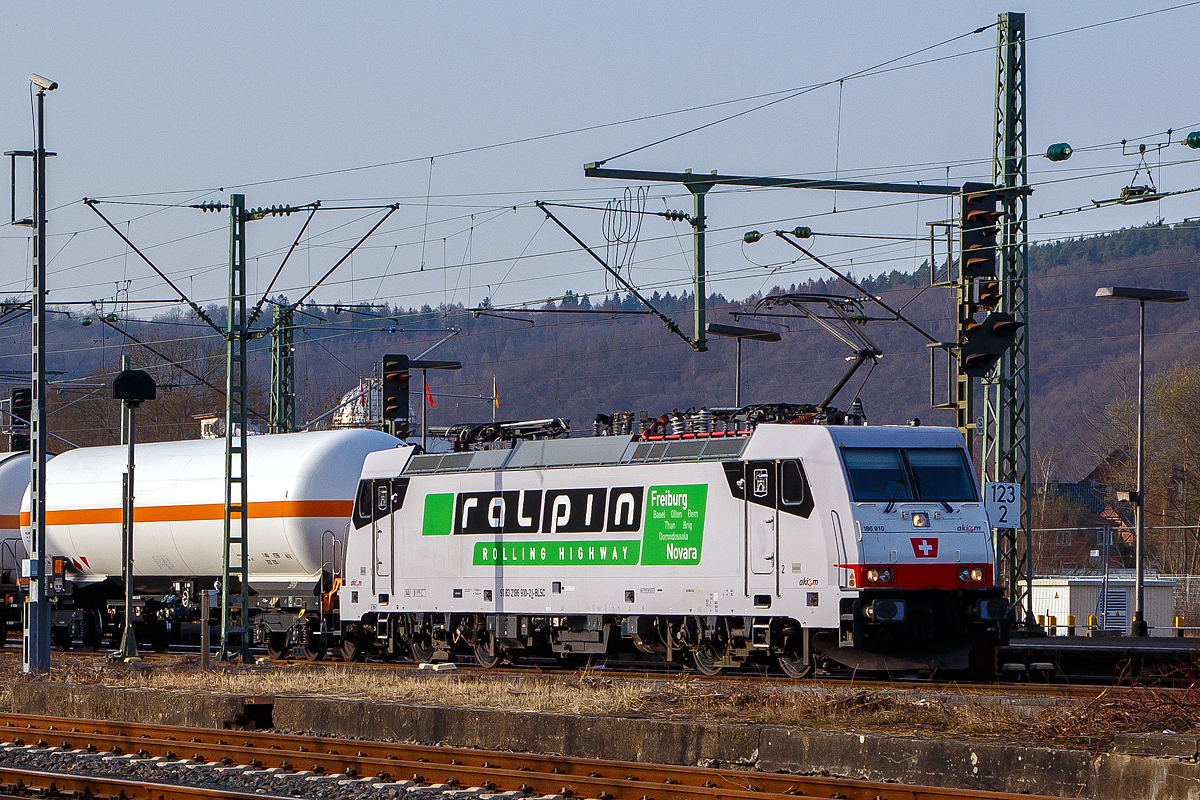 Die an die Cargologic AG (Kloten) vermieteten und bei der BLS Cargo AG eingestellten 186 910  (91 83 2186 910-2 I-BLSC) der AKIEM SAS, fährt am 03.03.2021 mit einem Kesselwagenzug durch Betzdorf (Sieg) in Richtung Siegen. Die Lok macht Werbung für die Rollende Landstraße (RoLa) Freiburg i.B. - Novara der RAlpin AG.

Die TRAXX F140 MS wurde 2008 von Bombardier in Kassel unter der Fabriknummer 3437 gebaut und hat die Zulassungen für Deutschland, Österreich, Schweiz und Italien. Ursprünglicher Eigentümer war das Leasingunternehmen CBRail S.à r.l., ab 2013 dann Macquarie European Rail Limited (Luxembourg) und nun die AKIEM SAS, die das Leasinggeschäft für Schienenfahrzeuge der Macquarie Europeto Rail im April 2020 erworben hat.

Die Station (Mieter) der TRAXX waren u.a.:
Geliefert an  CBRail S.à r.l. (Luxembourg)  als E 186 910, eingestellt von Bombardier Transportation Kassel unter NVR-Nummer 91 80 6186 910-6 D-BTK und vermietet an Linea S.p.A., Pozzolo Formigaro (Italien)
2012 Rail Cargo Italia S.r.l..
2014 vermietet an Crossrail AG (91 83 2186 910-2 I-XRAIL)
2017  vermietet an SBB Cargo International AG
Seit 2018 Cargologic AG, Kloten (ehemals Crossrail)