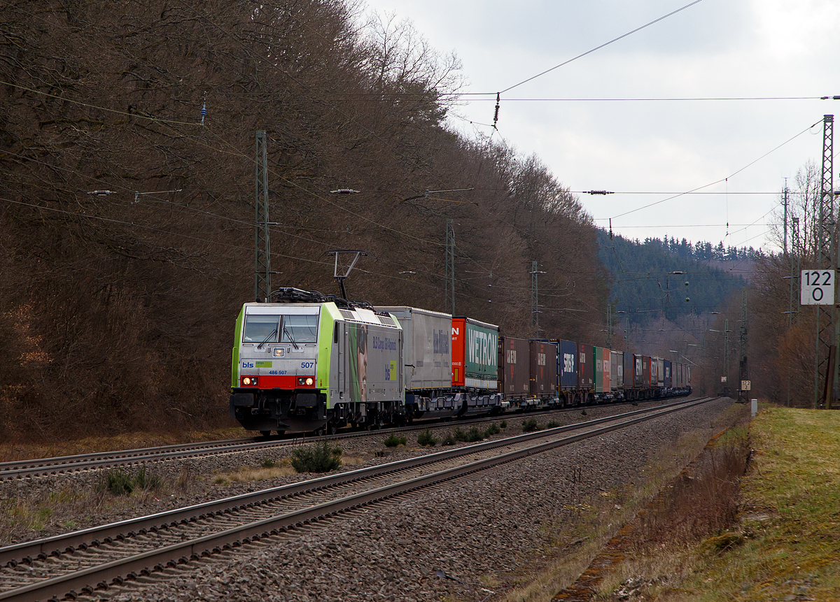 Die BLS Cargo 507, Re 486 507-7 (91 85 4486 507-7 CH-BLSC) fährt am 26.03.202, mit einem KLV-Zug, bei Dillbrecht über Dillstrecke (KBS 445) in nördlicher Richtung.

Die TRAXX F140 MS2E wurde 2008 von Bombardier in Kassel unter der Fabriknummer 34426 gebaut und an die BLS Cargo geliefert. Die Loks sind nur für die Schweiz, Deutschland, Italien und Österreich zugelassen.

Der Erfolg im Güterverkehr veranlasste die BLS zehn weitere TRAXX zu bestellen im Gegensatz zur ersten Serie TRAXX F140 AC1 mit der Bezeichnung Re 485 001 bis 485 020, die nur unter Wechselstrom fahren können, können die TRAXX F140 MS Re 486 501 bis 486 510 auch unter 3.000 Volt Gleichstrom eingesetzt werden. Bombardier hatte seit der ersten Lieferung Verbesserungen vorgenommen. Dabei wurde der Lokomotivkasten optimiert und die Traktionsausrüstung mit moderneren Komponenten versehen. Eine Nachbeschaffung wäre noch möglich gewesen, hätte aber dazu geführt, dass die Lokomotiven nicht auf dem neuesten Stand waren und nicht unter der Gleichstromfahrleitung eingesetzt werden konnten. Die eingebauten Zugbeeinflussungssysteme erlauben den Einsatz in Deutschland, Österreich, der Schweiz und Italien (DACHI). Anfänglich waren die Lokomotiven in der Schweiz nur für den Einsatz auf Strecken mit konventioneller Zugbeinflussung und nicht auf ETCS Level 2-Strecken zugelassen. Die Re 486 können unter sich und mit den Re 485 und Lokomotiven der Baureihe 185/186 in Vielfachsteuerung eingesetzt werden.

TECHNISCHE DATEN:
Spurweite:  1.435 mm (Normalspur)
Achsformel:  Bo’Bo’
Länge über Puffer:  18.900 mm
Höhe:  4.385 mm
Breite:  2.978 mm
Drehzapfenabstand:  10.400 mm
Achsabstand im Drehgestell: 2.600 mm
Dienstmasse:  85 t
Höchstgeschwindigkeit:  140 km/h
Dauerleistung:  5.600 kW
Dauerzugkraft:  300 kN
Treibraddurchmesser:  1.250 mm
Stromsysteme:  15 kV 16,7 Hz, 25 kV 50 Hz Wechselstrom sowie 3 kV und 1,5 kV Gleichstrom
Antrieb:  Tatzlager
