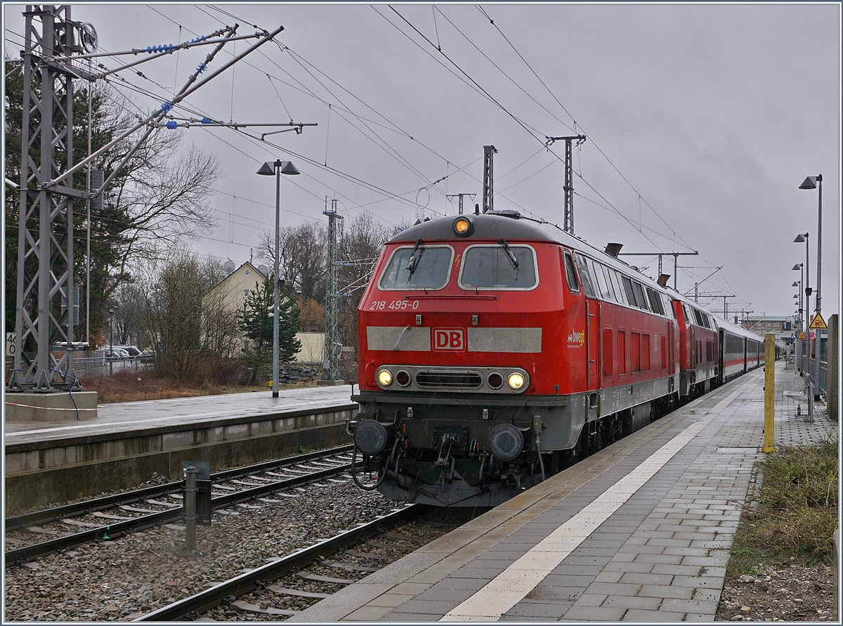 Die DB 218 495-0 und eine weitere mit ihrem IC 2012  Allgäu  Oberstdorf - Dortmund beim Halt im bereits elektrifizierten Bahnhof von Memmingen. 

15. März 2019