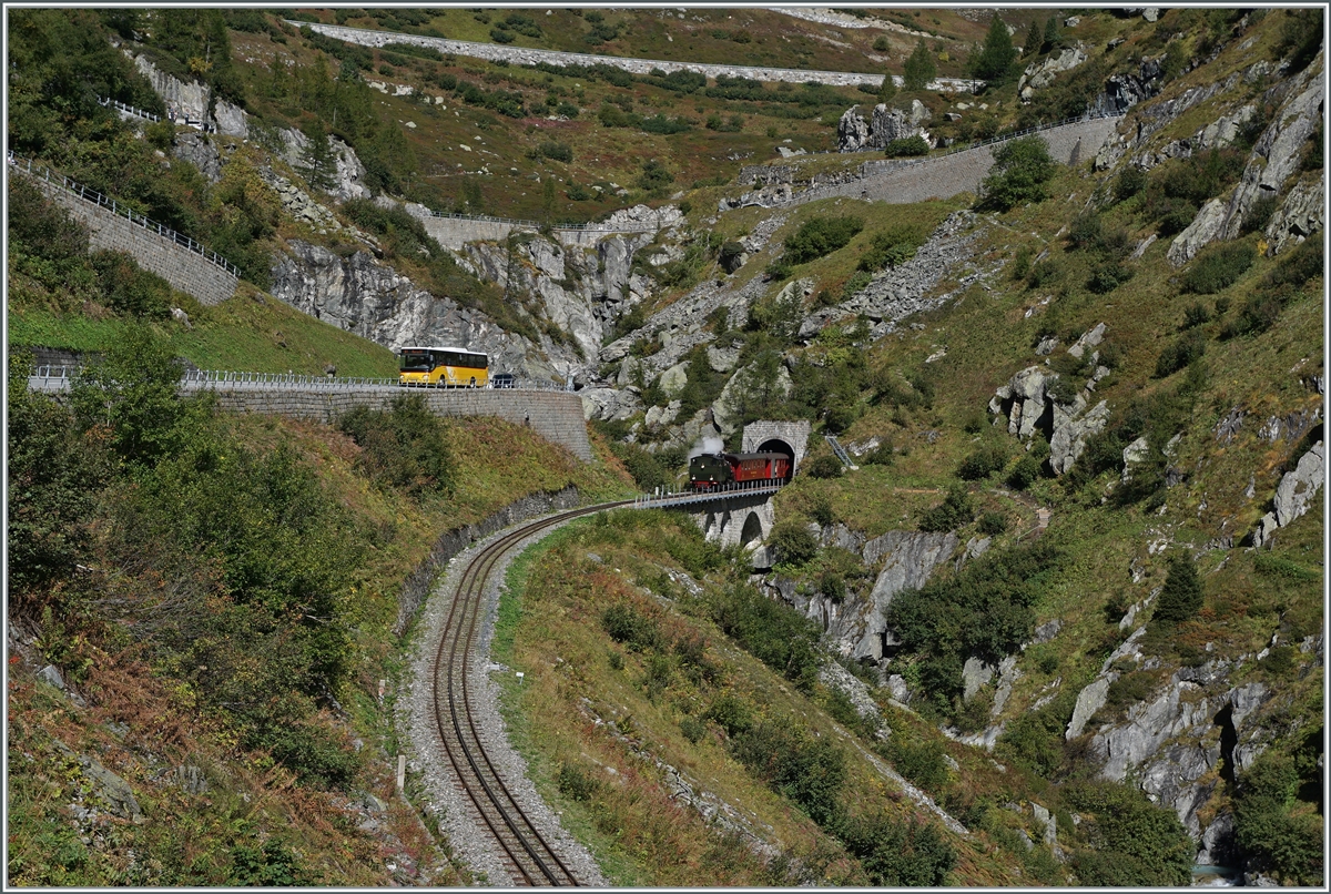 Die DFB HG 4/4 704 hat mit ihrem Zug den Kehrtunnel verlassen und fährt nun der jungen Rhone  entlang Oberwald zu; im Bild links, ein Postauto mit dem selben Ziel. 

30. Sept. 2021