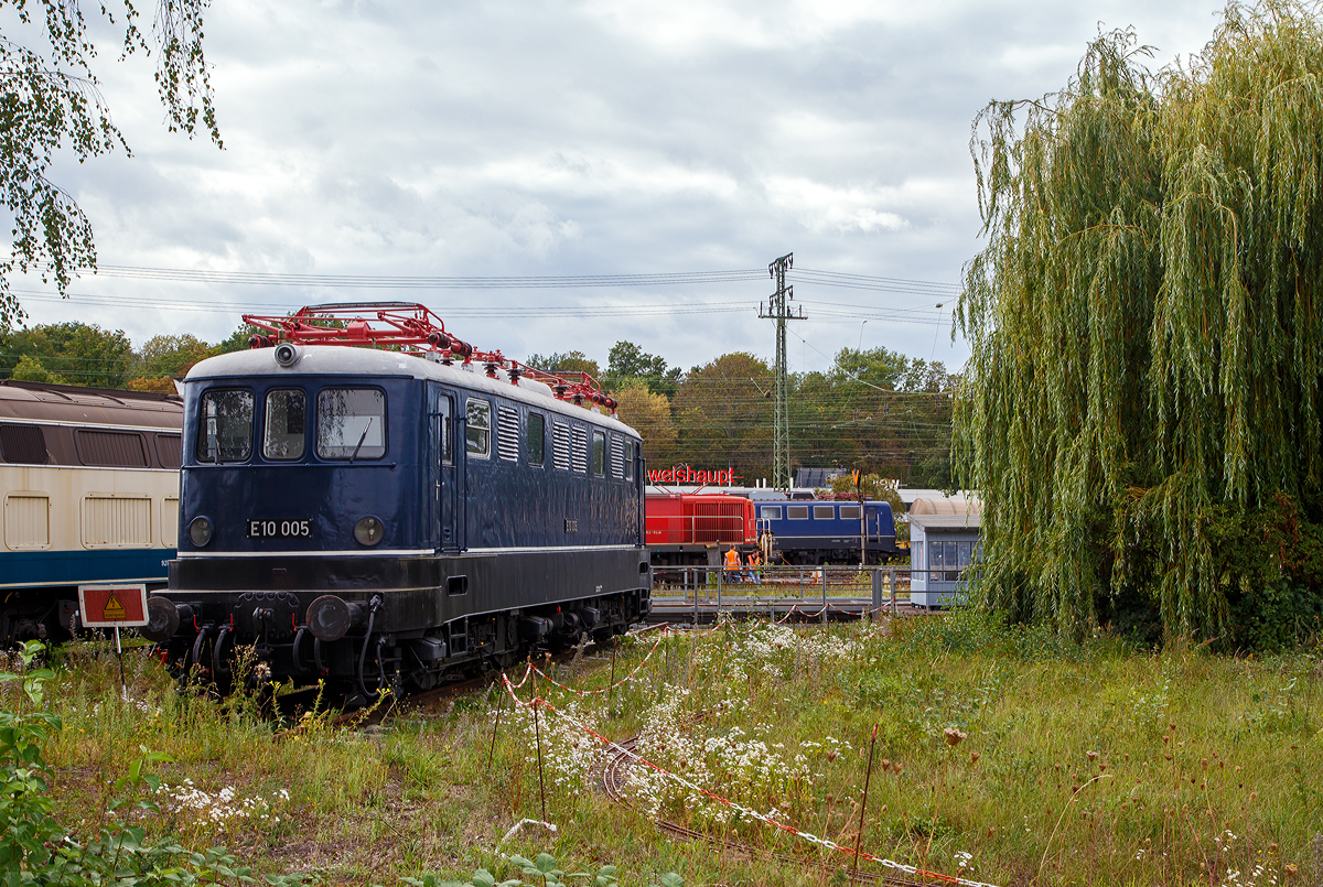 Die E 10 005, später 110 005–6, steht am 04.09.2020 im DB Museum Koblenz-Lützel. Diese fünfte Vorserien E 10 wurde 1953 von Henschel & Sohn in Kassel unter der Fabriknummer 28467 gebaut, die Elektrik wurde von AEG unter der Fabriknummer 7174 geliefert. Zum 30.08.1979, nach einer Laufleistung von 4,34 Mio. km, erfolgte die Ausmusterung bei der DB und 1980 wurde sie zur Museumslok.

Die Vorserienlokomotiven wurden weitgehend von der Industrie entwickelt, wobei verschiedene Komponenten ausprobiert wurden:
Die E 10 001 stammt im mechanischen Teil von Krauss-Maffei und im elektrischen Teil von AEG. Sie besaß einen Alsthom-Gelenkhebelantrieb.
Die E 10 002 stammt mechanisch von Krupp und elektrisch von BBC und hatte einen BBC-Scheibenantrieb.
Die E 10 003 kam von Henschel und SSW und hatte einen SSW-Gummiringfederantrieb.
Die E 10 004 lieferten Henschel und AEG und sie wurde durch einen Sécheron-Lamellenantrieb angetrieben. Baugleich mit ihr war die E 10 005, die 1953 nachgeliefert wurde, um die Lokomotiven auch im täglichen Betrieb testen zu können.

Die neuen Lokomotiven sollten Schnellzüge mit 700 t auf 10 ‰ mit 90 km/h und Güterzüge mit 1300 t auf 5 ‰ mit 70 km/h befördern können. Die Höchstgeschwindigkeit war mit 125 km/h angesetzt. Eine Zugkraft von 7 t am Radumfang war gefordert, wobei 6 t bereits 5 Sekunden nach dem Anfahren aus dem Stillstand erreicht werden mussten. Die Erwärmung der Fahrmotoren durfte 90 Grad nicht überschreiten. Auch durften Schwankungen bei der Fahrdrahtspannung zwischen 10,5 und 18,5 kV keine Betriebsstörungen verursachen. Die Loks sollten zweiachsige Drehgestelle mit Drehzapfen erhalten, wobei die Zugkraftübertragung über den Brückenrahmen und nicht mehr über die Drehgestelle (wie bei der E 44) erfolgen sollte. Auf Vorbauten, wie sie bei den Vorkriegselloks aus Sicherheitsgründen zu finden waren, glaubte man verzichten zu können. Schließlich war Vielfachsteuerung für den Einsatz in Doppeltraktion sowie die Ausrüstung für den Wendezugeinsatz einzubauen.

Gegenüber den Vorplanungen wurde die Höchstgeschwindigkeit auf 130 km/h heraufgesetzt und die Baureihenbezeichnung in E 10 umgewandelt. Entsprechend dem Schweizer Vorbild waren es Drehgestell-Lokomotiven mit einzeln angetriebenen Achsen jedoch mit unterschiedlichen Antrieben.

Die Auslieferung der Loks erfolgte im Zeitraum zwischen dem 23. August 1952 (E 10 001) und dem 23. März 1953 (E 10 005).

Die E 10-VorserienIoks sollten dazu dienen, möglichst viele neue Bauteile auf ihre Verwendbarkeit für die künftigen Serienloks zu testen. Deshalb unterschieden sie sich weitgehend voneinander und von den folgenden Serienloks.
Einige Bauteile waren jedoch im Prinzip gleich aufgebaut und nur in der Ausführung etwas verschieden. Dazu gehörte der Brückenrahmen, der bei allen Loks aus kastenförmig zusammengeschweißten Stahlblechen bestand. Er setzte sich jeweils aus zwei Längsträgern, zwei Kopfstücken, drei Querträgern (für die Drehzapfen und den Trafo) sowie Deckblechen zusammen und musste die Zug- und Stoßkräfte aufnehmen.
Auch der Kastenaufbau war bei allen Vorserienloks ähnlich konstruiert. Er bestand jeweils aus einem selbsttragenden Gerippe von Stahlprofilen, die auf den Brückenrahmen geschweißt waren und durch angeschweißte Mantelbleche verkleidet wurden.

Die fünf Vorserien-Lokomotiven der Baureihe E 10.0 wurden zwischen 1975 und 1979 ausgemustert. Erhalten sind die Museumslokomotiven E 10 002 und E 10 005.

TECHNISCHE DATEN der E10 004 und 005:
Spurweite: 1.435 mm
Achsanordnung: Bo´Bo´
Länge über Puffer: 15.900 mm
Treibraddurchmesser: 1.250 mm (neu)
Dienstgewicht: 80 t
Achslast: 20 t
Höchstgeschwindigkeit : 130 Km/h
Anfahrzugkraft: 255 kN
Dauerzugkraft: 118 kN
Nennleistung: 3.440 kW
Anzahl Fahrmotoren 4
Stromsystem: Einphasen-Wechselstrom 15 000 V, 16 2/3 Hz 