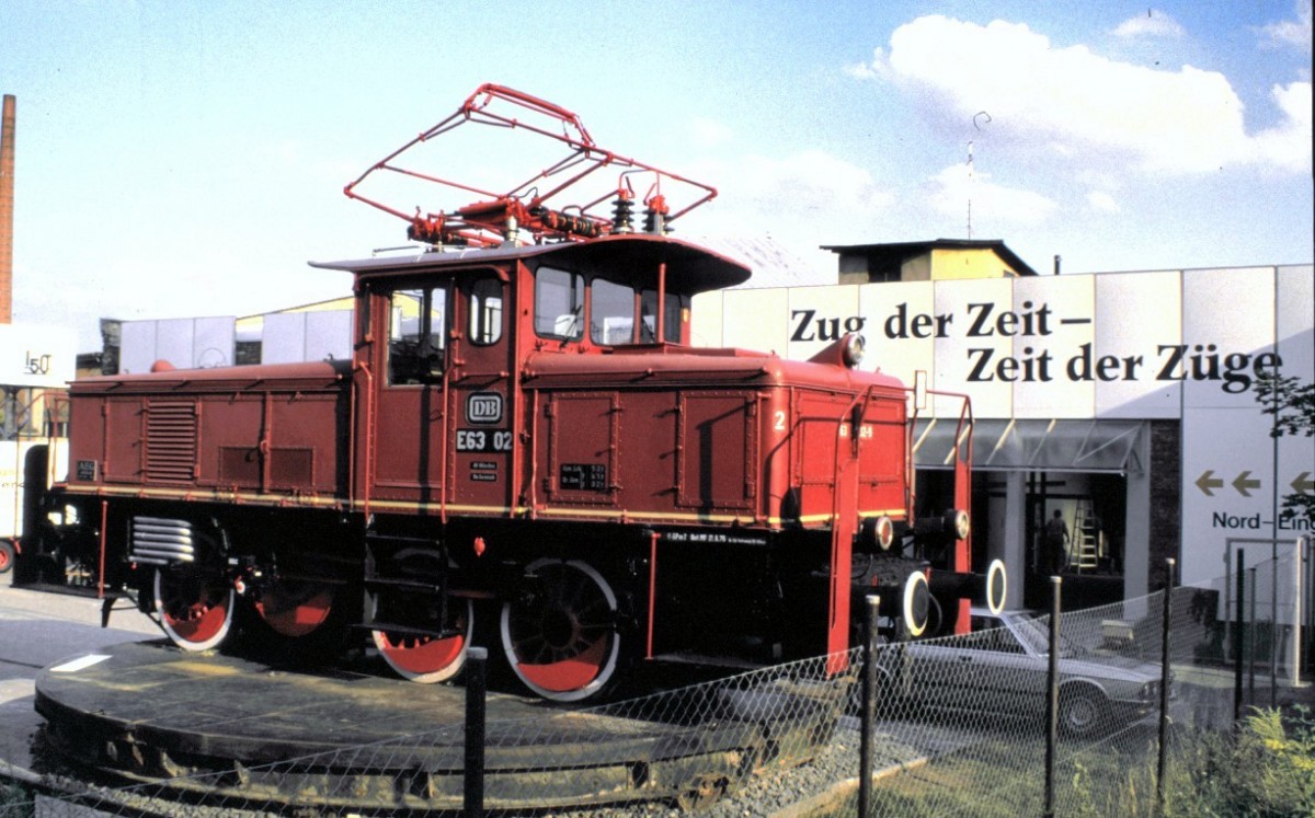 Die E 63 02 steht zum 150 jhrigen Jubilum Eisenbahn in Deutschland vor dem Eingang zur Veranstaltung:  Zug der Zeit - Zeit der Zge  in Nrnberg am 18.08.1985.