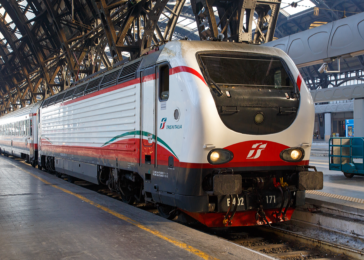 
Die E.402.171 (91 83 2402 171-9 I-TI) der Trenitalia (100-prozentige Tochtergesellschaft der Ferrovie dello Stato) ist am 29.12.2015 mit einem Frecciabianca (deutsch: weißer Pfeil) in den Bahnhof Milano Centrale (Mailand Zentral) eingefahren. Der Frecciabianca ist eine Zuggattung für Züge (IC) mit einer Höchstgeschwindigkeit von 200 km/h.

Die FS E.402B ist eine Weiterentwicklung der E.402A, verfügt jedoch gegenüber ihrem Vorgängermodell zum Beispiel über ein höheres Gewicht sowie einen neu gestalteten und futuristischeren Wagenkasten. Die Höchstgeschwindigkeit ist jedoch mit 200 km/h etwas geringer als bei der E.402A (mit 220 km/h). Von den Lok wurden 80 Stück zwischen 1997 und 2000 von AnsaldoBreda und Sofer gebaut.

Die Baureihe E.402B ist eine Mehrstromlokomotive, sie kann unter 3000 V Gleichstromspannung, dem hauptsächlichen italienischen Bahnnetz, aber auch auf den italienischen Schnellfahrstrecken mit 25 kV, 50 Hz Wechselstrom fahren. Fernerhin kann sie unter 1500 V Gleichstrom betrieben werden, dann hat sie aber nur die halbe Leistung. 

Die Lok ist eine vollelektronische Chopperlokomotive, das heißt, wenn die Lokomotiven unter 3000 V DC fährt, wird der Strom mit Hilfe eines Zerhackers in Wechselstrom umändern, der dann schließlich die Motoren antreibt. 

Technische Daten:
Spurweite:  1435 mm (Normalspur)
Achsformel: Bo'Bo'
Länge: 19.420 mm
Drehzapfenabstand: 10.450 mm
Achsabstand im Drehgestell: 2.850 mm
Dienstgewicht: 89 t
Höchstgeschwindigkeit: 200 km/h
Stundenleistung: 6.000 kW
Dauerleistung: 5.600 kW
Anfahrzugkraft: 280 kN
Treibraddurchmesser:  1.250 mm
Stromsysteme: 3000 V DC, 25 kV - 50 Hz AC und 1500 V DC (bei halber Leistung)