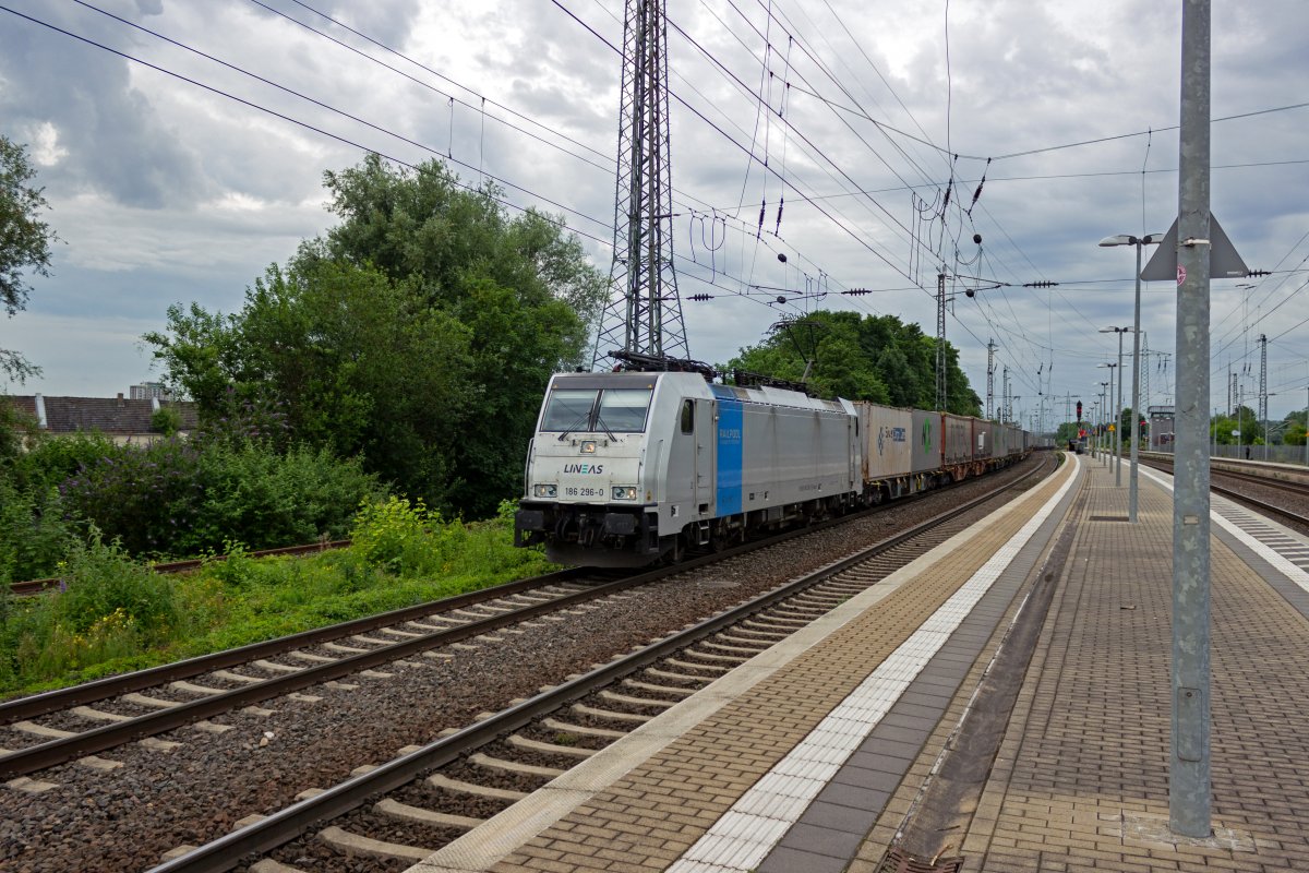 Die ehemalige G�terverkehrssparte der Belgischen Staatsbahn firmiert seit ihrer Privatisierung unter dem Namen LINEAS. Die von Railpool gemietete 186 296 zieht am 08.07.2021 f�r dieses Unternehmen einen Containerzug durch H�rth in Richtung K�ln.