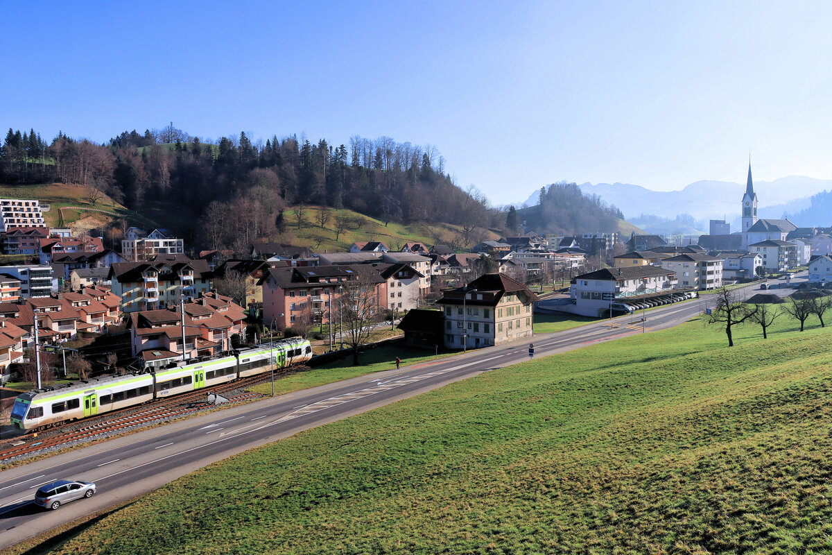 Die ehemalige VHB (Vereinigte Huttwil-Bahnen) / Strecke der ursprünglichen Huttwil-Wolhusen Bahn (HWB): Früher konnte man Aufnahmen mit der Kirche Menznau und dem Bahnhof machen, heute ist alles verbaut, und es wird noch weiter verbaut. So ist ein Blick der BLS NINA bei der Ausfahrt Richtung Huttwil mit Sicht auf die Kirche nur in dieser Fernschau möglich. 31.Dezember 2021. Als kleines Detail die Ablenkung des Nebengleises im Vordergrund, damit Züge aus dem Areal der SwissKrono nicht unerlaubt ins Hauptgleis gelangen.   