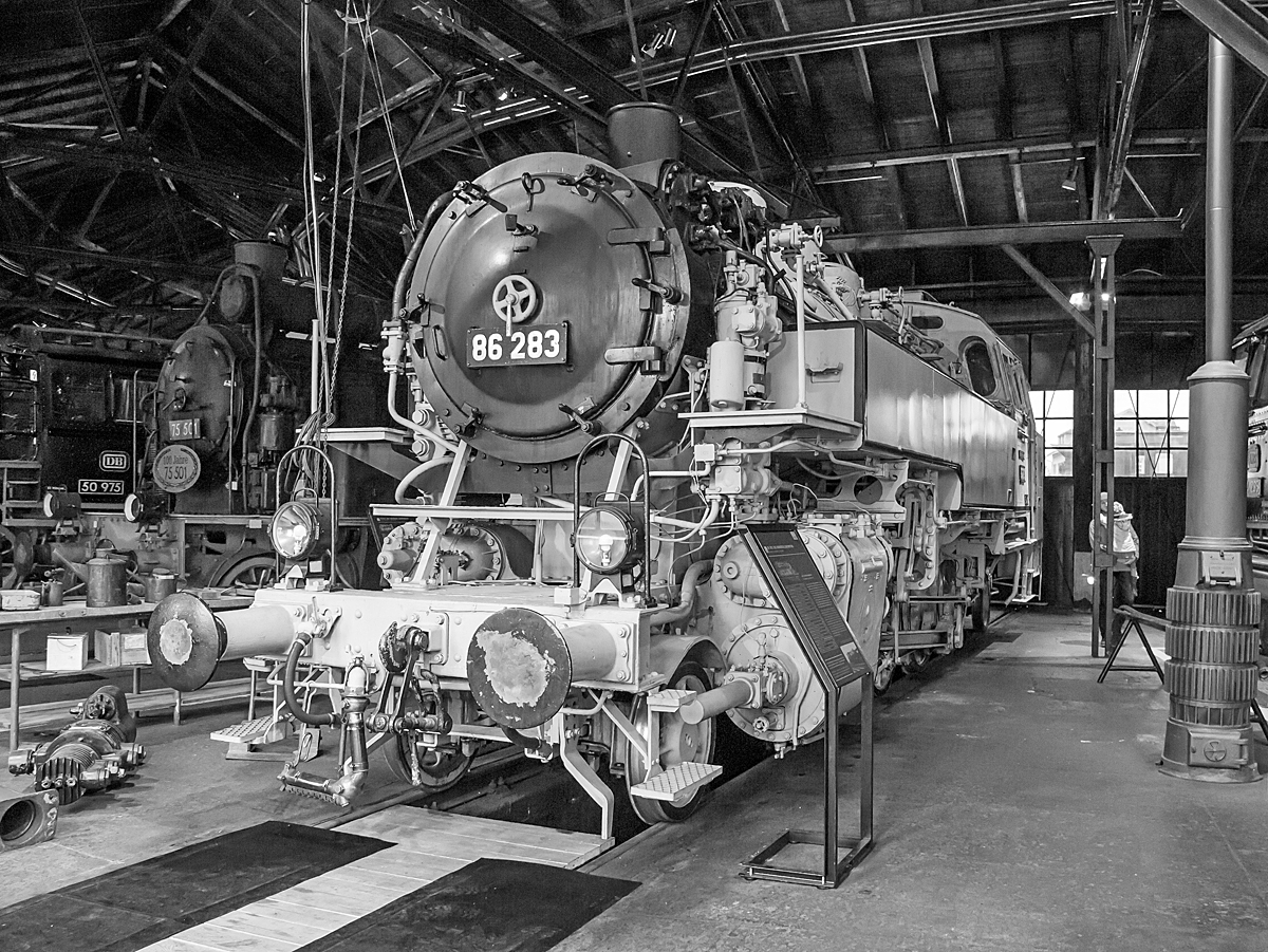Die Einheits-Güterzugtenderlokomotive 86 283 im hellgrau-schwarzen Fotoanstrich, ex  DB 086 283-9, am 26.03.2016 Deutschen Dampflokomotiv-Museum in Neuenmarkt-Wirsberg.

Die 1D1-Tenderlokomotive (vierfach gekuppelte Tenderlokomotive) wurde 1937 von 	Orenstein & Koppel  in Babelsberg unter der Fabriknummer 12912 gebaut DRG geliefert. Nach dem Krieg blieb sie im Westen und kam so zur Deutschen Bundesbahn, wo sie nach dem EDV-Nummernplan 1968 in DB 086 283-9 umgezeichnet wurde. Im Jahr 1974 wurde sie dann bei der DB ausgemustert.

Die Baureihe 86 wurde als Einheits-Güterzugtenderlokomotive von der Deutschen Reichsbahn entworfen. Sie war für den Einsatz auf den Nebenstrecken vorgesehen und wurde von fast allen für die Reichsbahn tätigen Unternehmen geliefert. Die ersten Lieferungen (wie diese hier) waren noch mit Bissel-Laufachsen ausgerüstet, die Maschinen mit den Betriebsnummern 86 293-296 und ab der Nummer 86 336 erhielten aber dann Krauss-Helmholtz-Gestelle. Dadurch konnte die Höchstgeschwindigkeit von 70 auf 80 km/h heraufgesetzt werden, die Gesamtlänge wuchs auf 13.920 mm. Ab 1942 wurde sie in einer vereinfachten Form als Übergangskriegslokomotive (ÜK) gebaut. Im Zeitraum von 1928 bis 1943 wurden 775 Exemplare gebaut, von denen alle bis auf zwei Maschinen nach dem Zweiten Weltkrieg wieder aufgefunden wurden. 

385 Maschinen verblieben auf dem Netz der Deutschen Bundesbahn in Westdeutschland, wovon 8 Lokomotiven wegen Kriegsschäden bis 1952 ausgemustert wurden. Die Deutsche Reichsbahn konnte nach Abgabe von 71 Loks an die Sowjetischen Eisenbahnen (S´D) von dann noch vorhandenen 172 Exemplaren 164 in den Betriebsbestand aufnehmen.

TECHNISCHE DATEN (dieser Lok bzw. der ersten Serien):
Spurweite: 	1435 mm (Normalspur)
Achsformel: 1'D1'
Bauart: 1'D1' h2t
Gattung: Gt 46.15
Länge über Puffer: 13.820 mm
Höhe: 4.165 mm
Kleinster bef. Halbmesser: 	140 m
Leergewicht: 70,0 t
Dienstgewicht: 88,5 t
Achslast:15,6 t
Höchstgeschwindigkeit :70 km/h (vorwärts und rückwärts)  
Indizierte Leistung: 1031 PSi
Kuppelraddurchmesser: 1.400 mm
Laufraddurchmesser (vorn / hinten): 850 mm
Steuerungsart: außenliegende Heusinger-Steuerung
Zylinderanzahl: 	2
Zylinderdurchmesser: 	570 mm
Kolbenhub: 660 mm
Kessellänge: 4.500 mm
Kesselüberdruck: 14 kp/cm² (14 bar)
Wasservorrat: 9,0 m³
Kohlevorrat: 4,0 t

Laufleistung der 82 283 über 1,5 Mio. km
