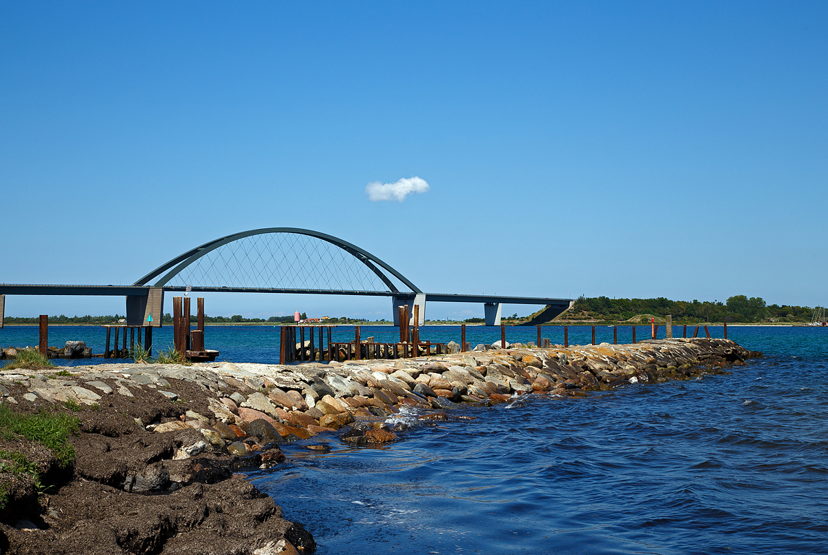 Die Fehmarnsundbrücke am 12.06.2015 aufgenommen von  Grossenbroder Fähre, rechts die Insel Fehmarn.

Die Fehmarnsundbrücke ist eine kombinierte Straßen- und Eisenbahnbrücke, die die Insel Fehmarn in der Ostsee mit dem Festland bei Großenbrode verbindet, sie wurde 1963 eröffnet. 

Die 963 Meter lange Brücke überspannt den 1300 Meter breiten Fehmarnsund, wobei die restlichen 337 Meter aus beidseitigen Rampen bestehen. Sie hat eine lichte Höhe von 23 Metern über dem Mittelwasser und bietet für den Schiffsverkehr einen Durchgang von 240 Metern Breite sowie eine Durchfahrtshöhe von 23 Metern über NN. Sie ist eine Stahlkonstruktion mit 21 Metern Breite, von denen sechs Meter von der Deutschen Bahn genutzt werden. Der zirka 268,5 Meter lange Bogen hat eine Stützweite von 248 Metern und ist mit 45 Metern über der Fahrbahn höchster Punkt. Nach einer Festen Fehmarnbeltquerung, welche gebaut wird, ist die vorhandene Fehmarnsundbrücke den höheren Belastungen nicht mehr gewachsen.

Bis 1963 existierte eine Eisenbahnfähre von Großenbrode Fähre über den Fehmarnsund bis zum gleichnamigen Ort Fehmarnsund auf der Insel Fehmarn. Für die Verbindung nach Dänemark gab es, von 1951bis 1963 die Eisenbahnfähre (Trajektverkehr) vom Bahnhof Großenbrode Kai (D) nach Gedser (DK). Nach Fertigstellung der Fehmarnsundbrücke und der Eröffnung der Vogelfluglinie wurde der Trajektverkehr auf Puttgarden (D)und Rødbyhavn (DK) verlegt. Zum 14. Dezember 2019 wurde die Eisenbahnfährverbindung auf der Vogelfluglinie aufgrund von Gleisarbeiten auf dänischer Seite im Zuge des Baus des Fehmarnbelttunnels eingestellt.
So ist heute die Verbindung Rostock (D) nach Trelleborg in Schweden die letzte Eisenbahnfährverbindung in Deutschland, wobei hier nur Güterverkehr stattfindet. 
