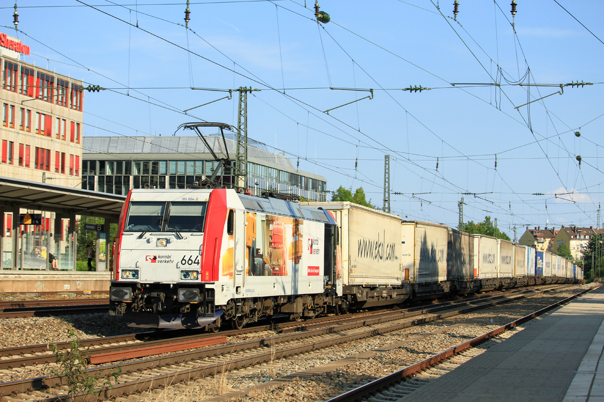 Die fr Kombiverkehr werbende 185 664 () durchfhrt mit einem Klv den Bahnhof Mnchen Heimeranplatz in Richtung Laim. Das Foto entstand am frhen Abend des 17.August 2018.