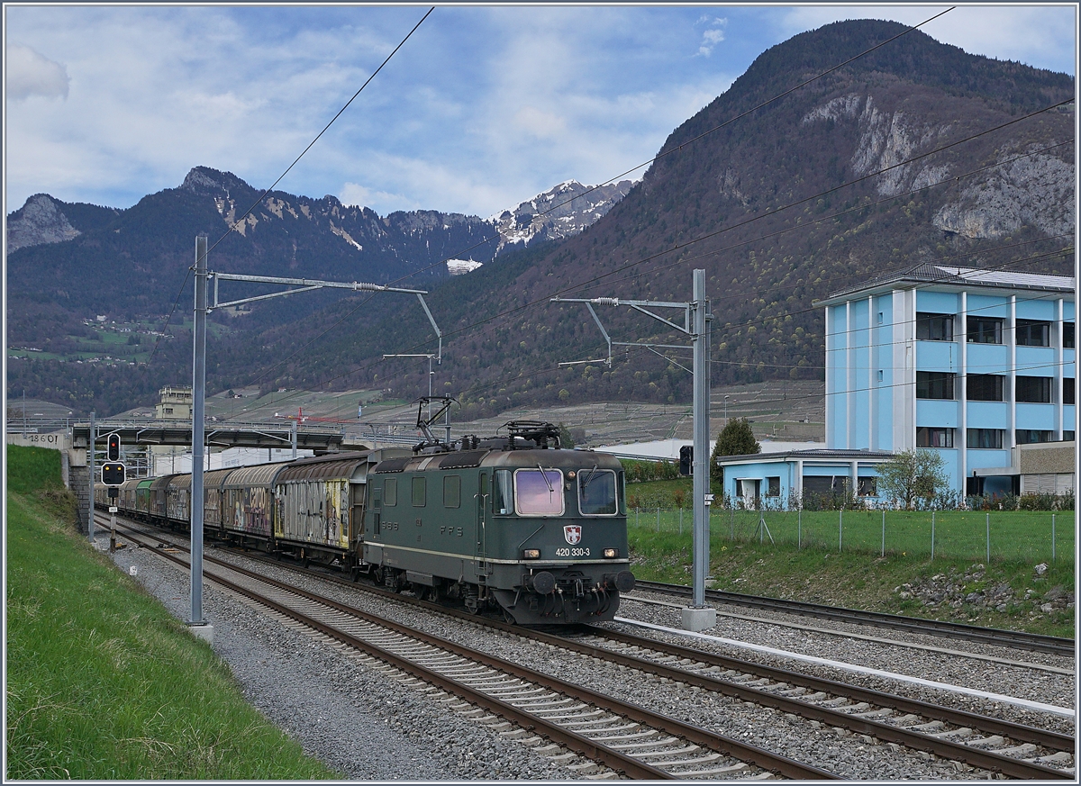 Die grüne SBB Re 420 330-3 mit einem Güterzug Richtung Wallis bei der Ausfahrt in Aigle. 

12. April 2018